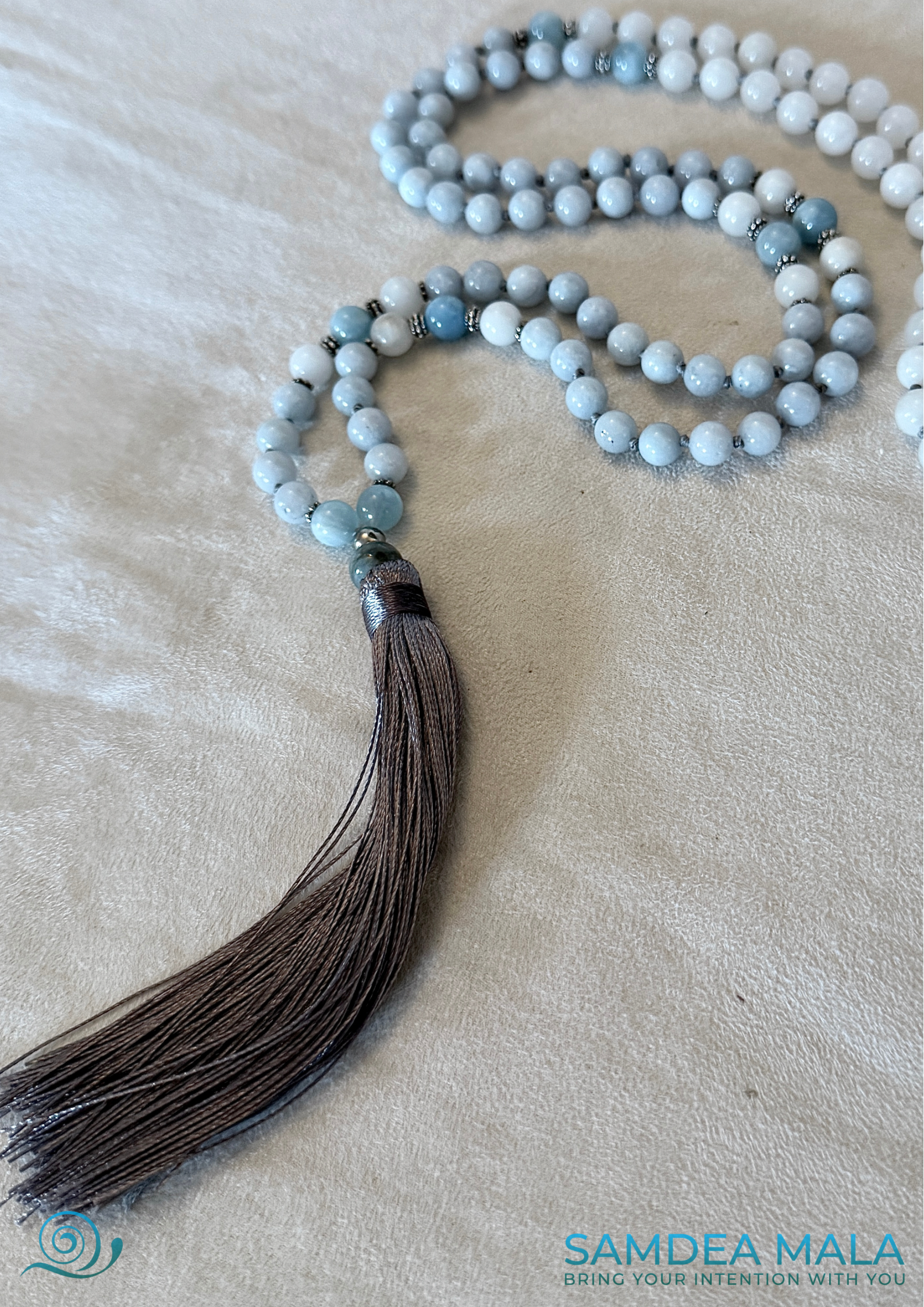Close-up of 108 Mala beads for meditation in Aquamarine and White Jade with Tassel for peace and presence - OM charm