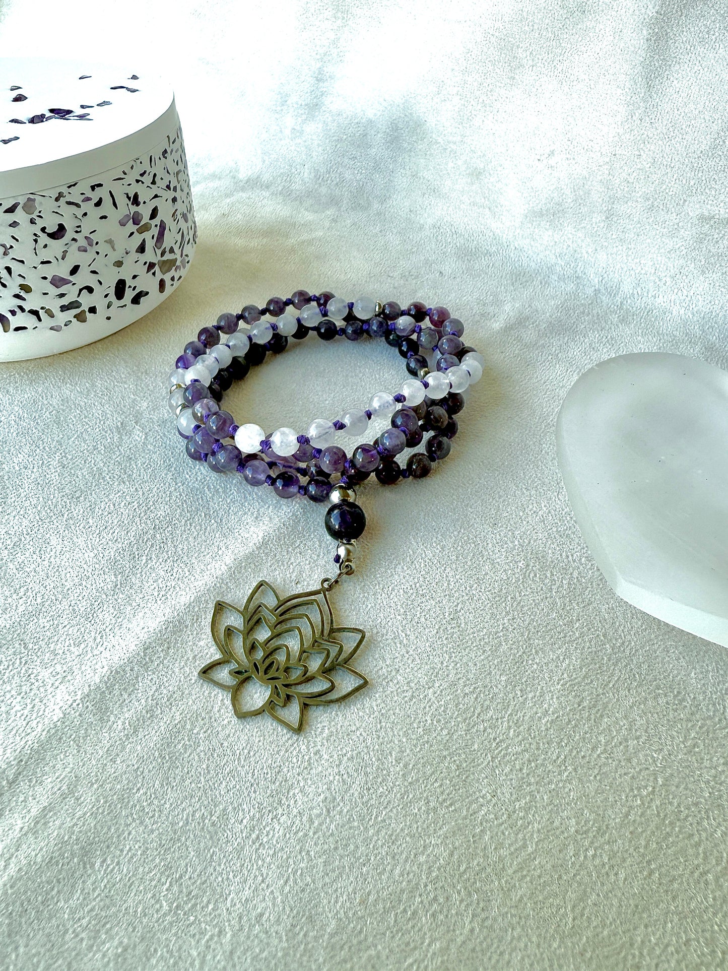 108 prayer beads close-up—6mm amethyst knots visible between stones lotus pendant