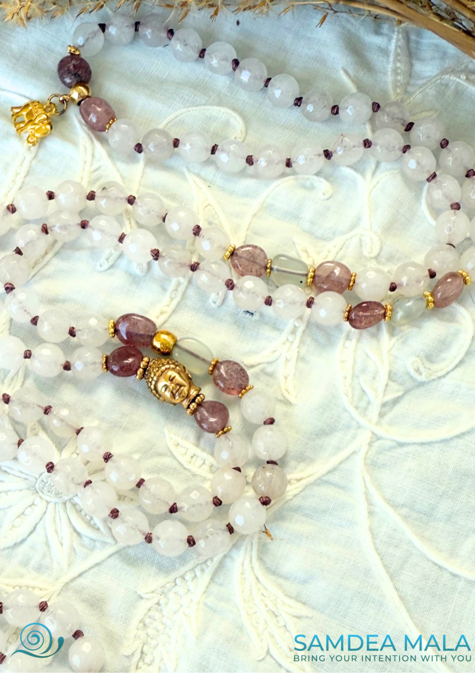 Close-up of pink 108 bead mala beads for heart chakra, with buddha charm, made with natural rose quartz and strawberry quartz