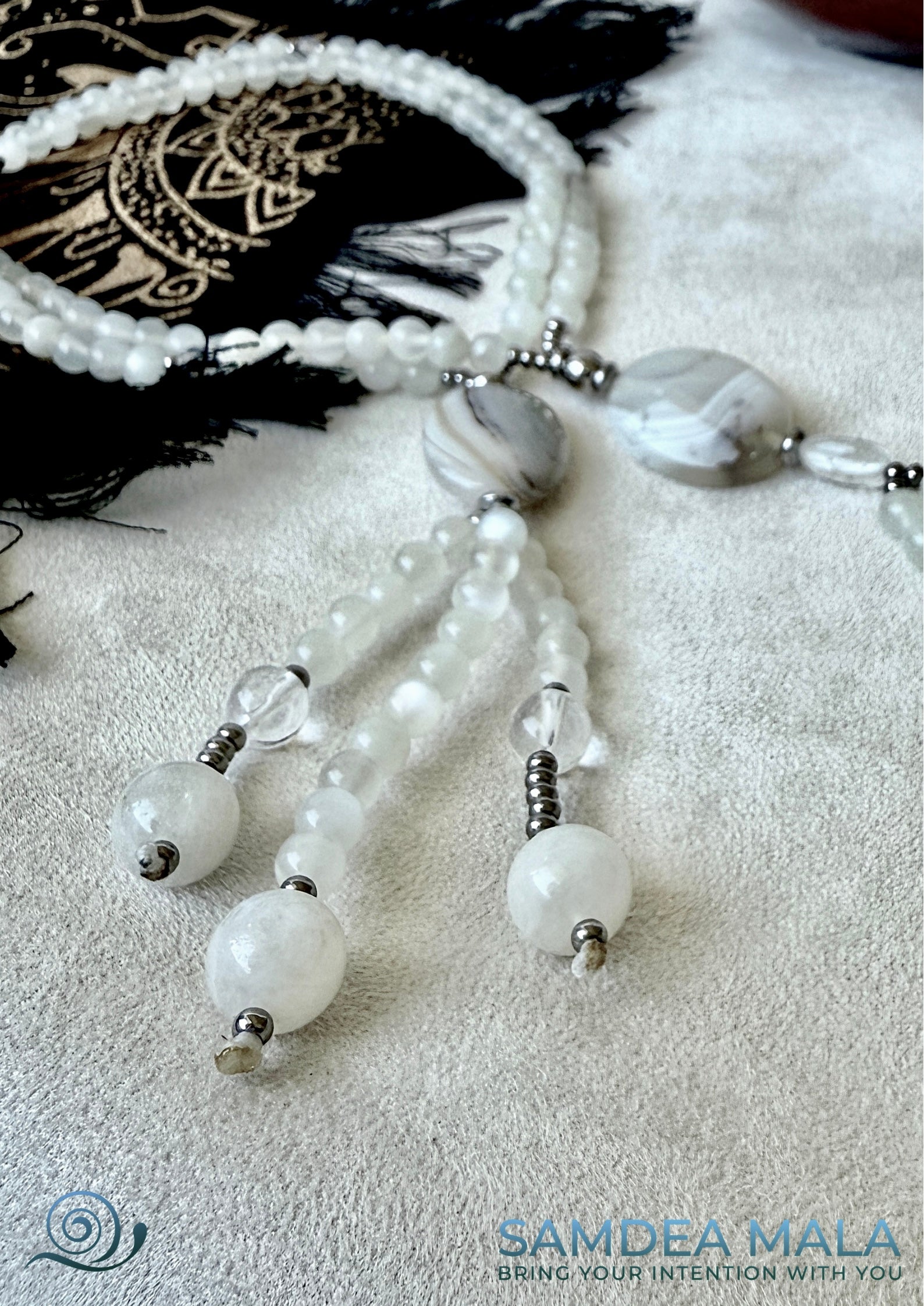 Close-up of Nichiren prayer beads with white agate, grey chalcedony, and moonstone. Handcrafted Juzu for chanting Nam Myoho Renge Kyo – moonstone and agate design.