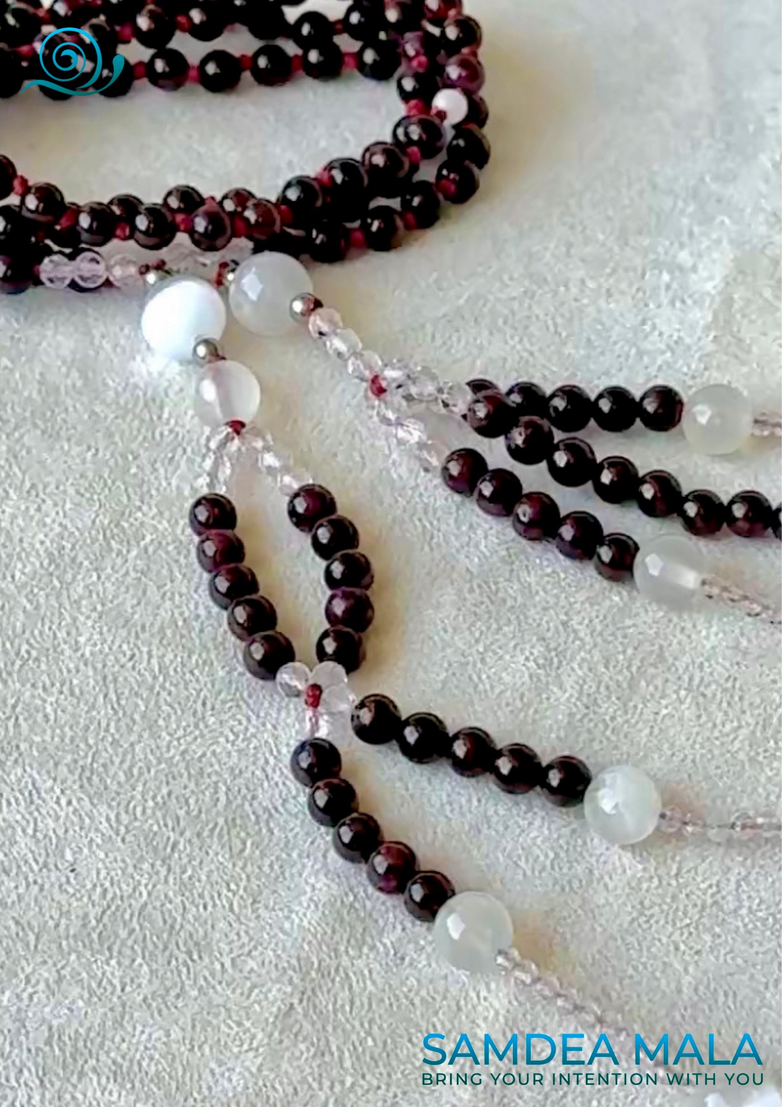 Close-up of Buddhist prayer beads in garnet and quartz – hand-knotted with intention