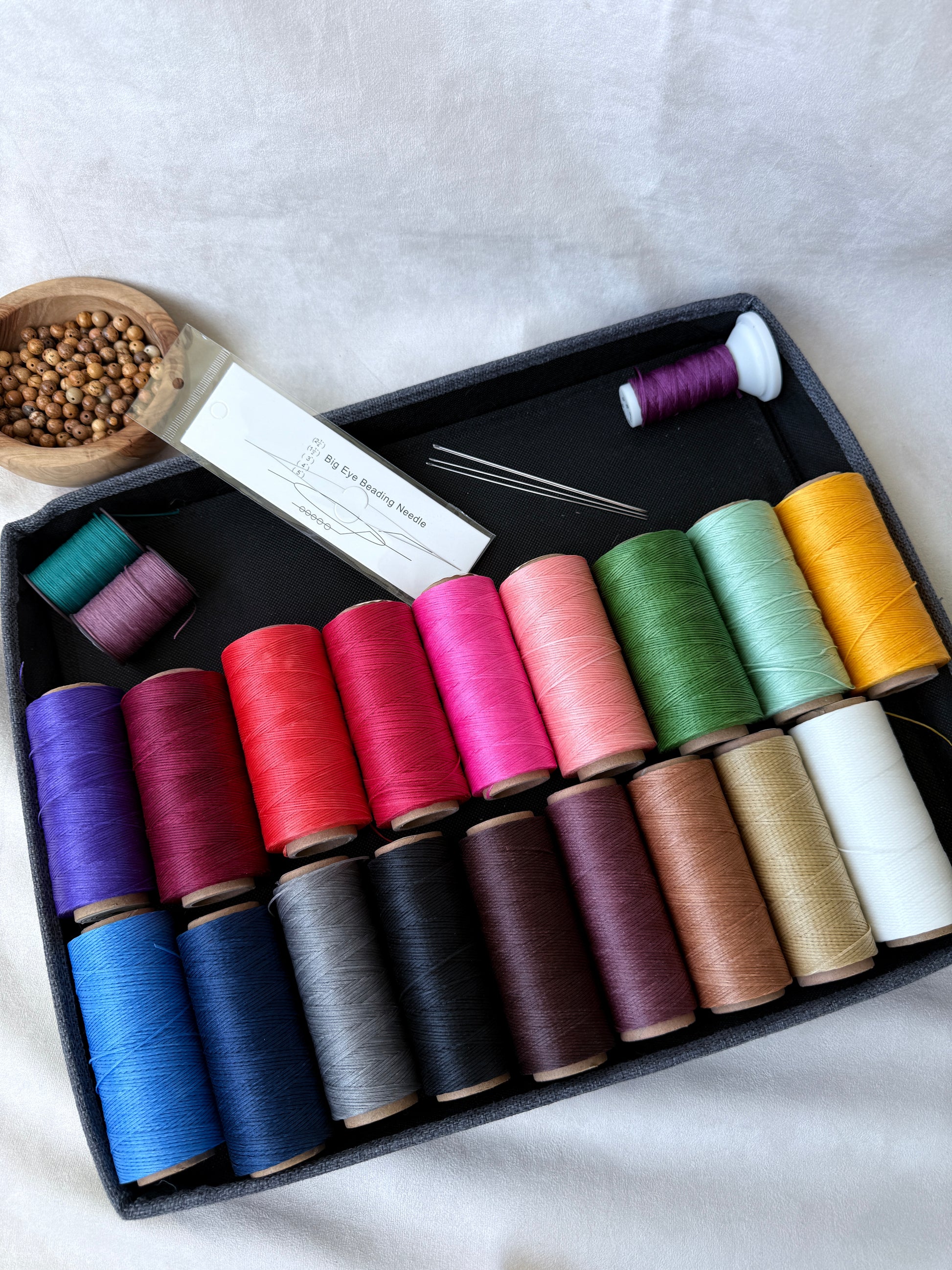 Samdea Mala DIY thread and needle kit. Mala crafting tools: spool of flat thread with beading needles. DIY mala making materials. Large-eye and standard beading needles for mala repair. Handmade mala repair kit with calm spiritual setup.