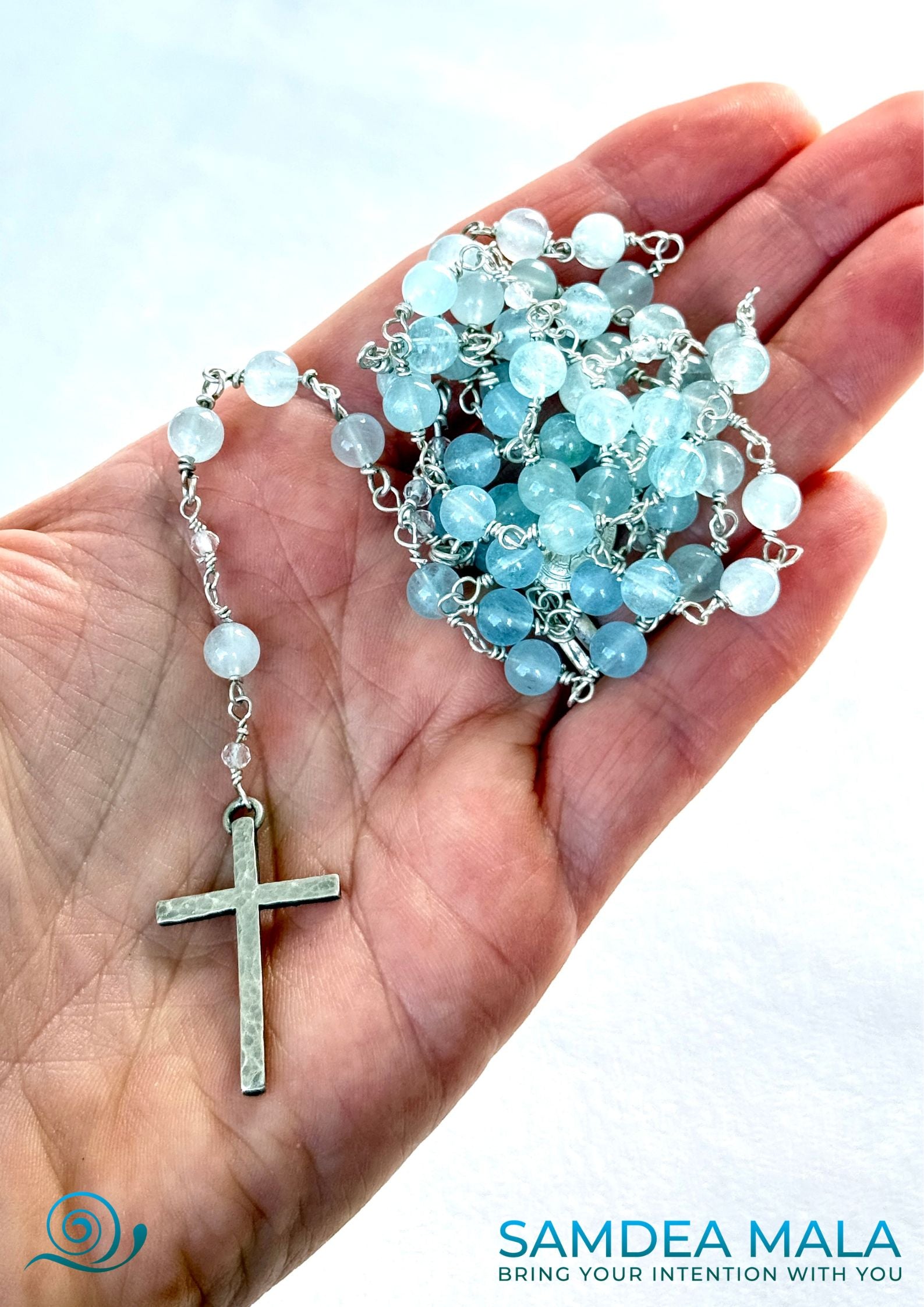 A hand holding Samdea Mala handmade sterling silver rosary with aquamarine and clear quartz Catholic rosary with vintage silver cross, made in US. Handmade Catholic rosary. Handmade Rosary, Semi Precious Stone Rosary, Catholic Prayer Beads, Christian Meditation Beads, Spiritual Gift, Unique Rosary, Faith Jewelry, Rosary Necklace
