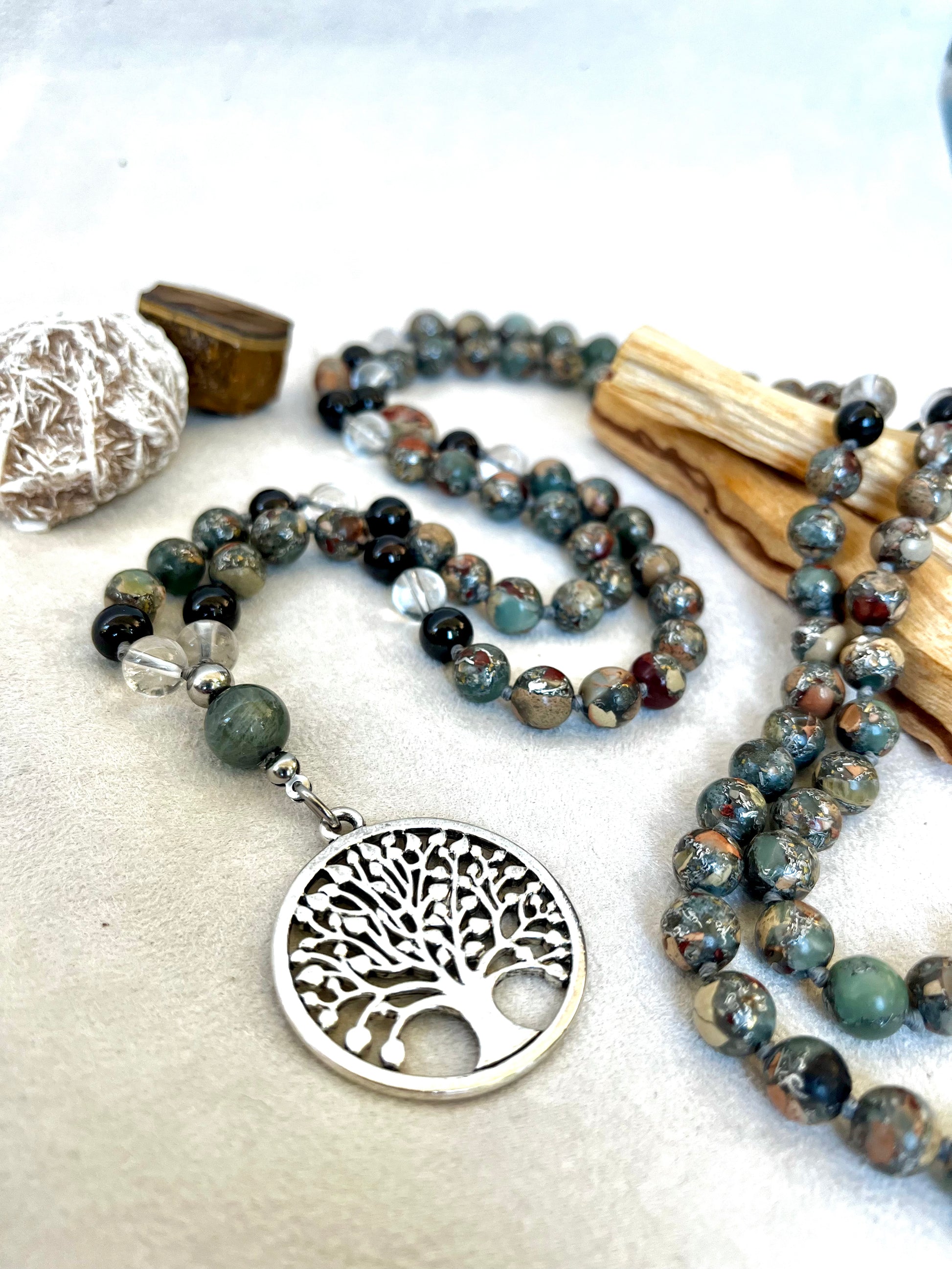 Full mala with 108 beads laid on natural background Mala 4 Elements: Aqua, Earth, Air, and Fire with tree of life pandant