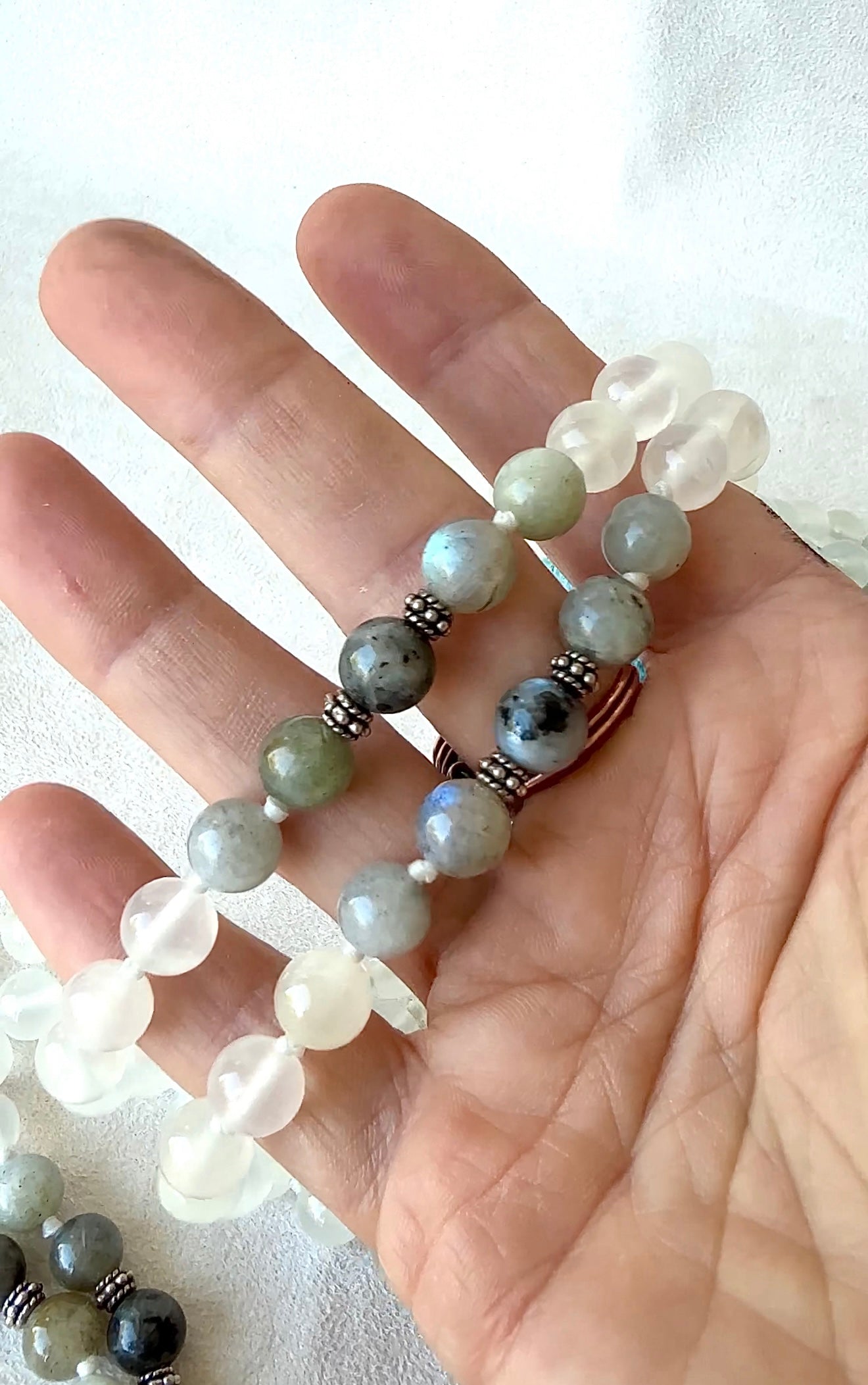 Close-up of labradorite beads in a White hand-knotted Mala for meditation in selenite