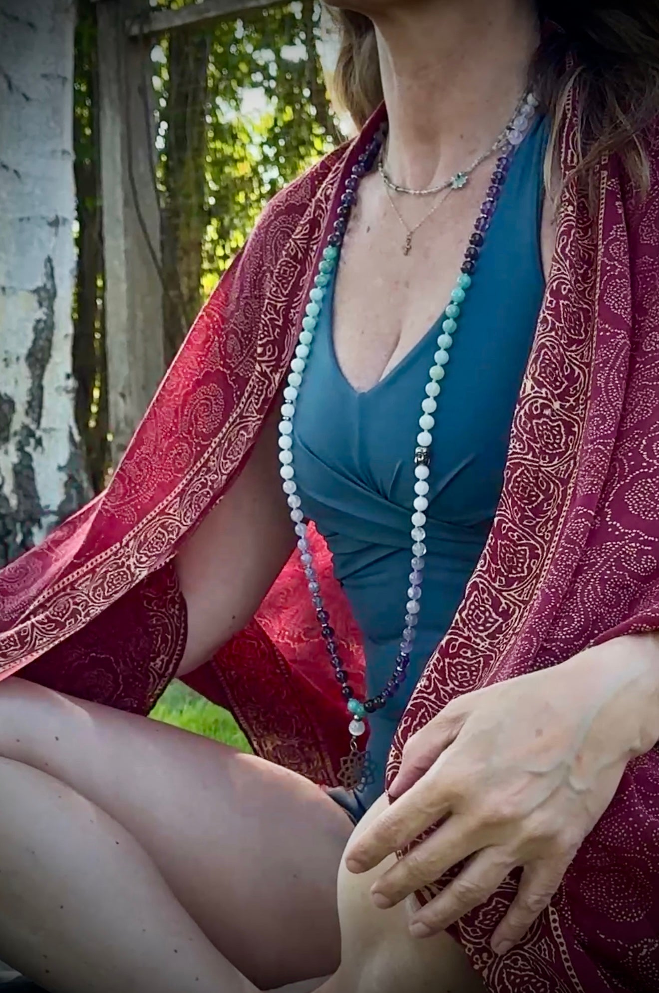 Sacred mala beads with soft green, lavender and white tones – perfect mindfulness gift. Mala for Pisces Zodiac Sign. Buddha charm, seed of life pendant and lotus charm. Full view worn by Marina Boccadifuoco. @mariblunotte