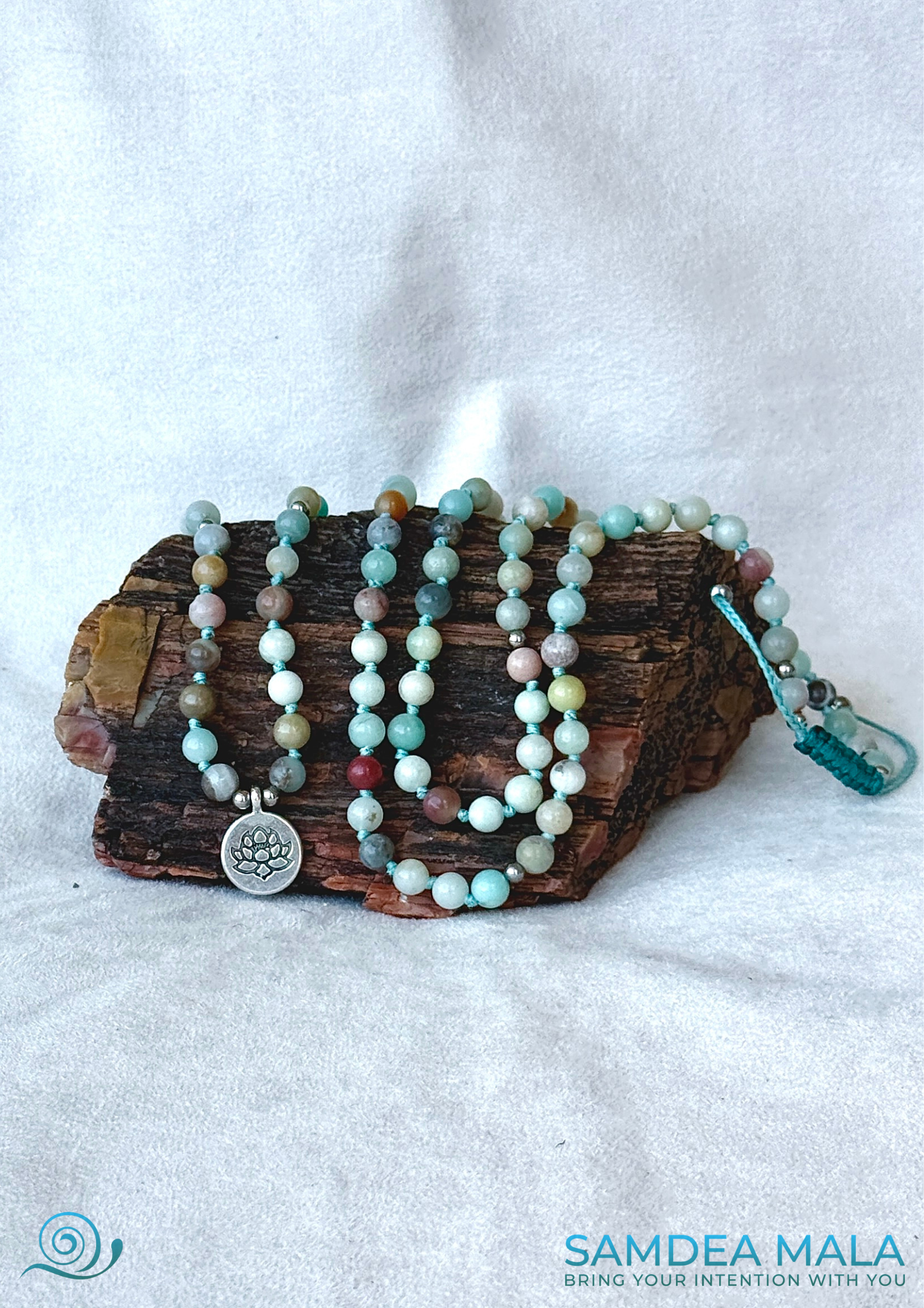 Mala bracelet in Amazonite with natural gemstones with a lotus charm for meditation and mindfulness on a pertified wood stone.