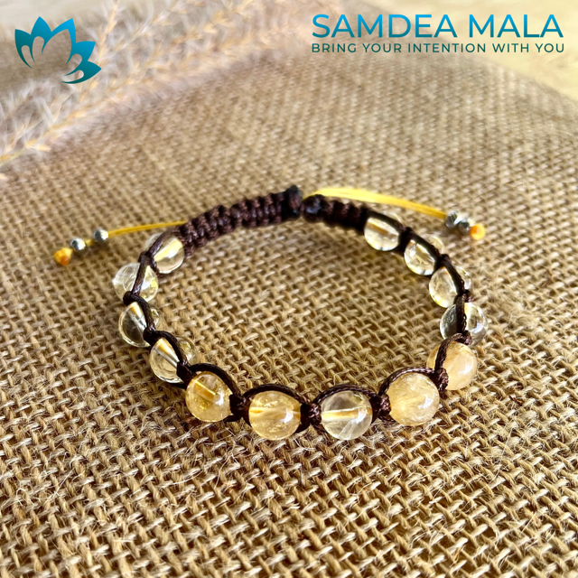 Samdea Mala bracelet featuring golden yellow quartz beads on a brown cord. This handcrafted mala bracelet is perfect for meditation and mindfulness practices.