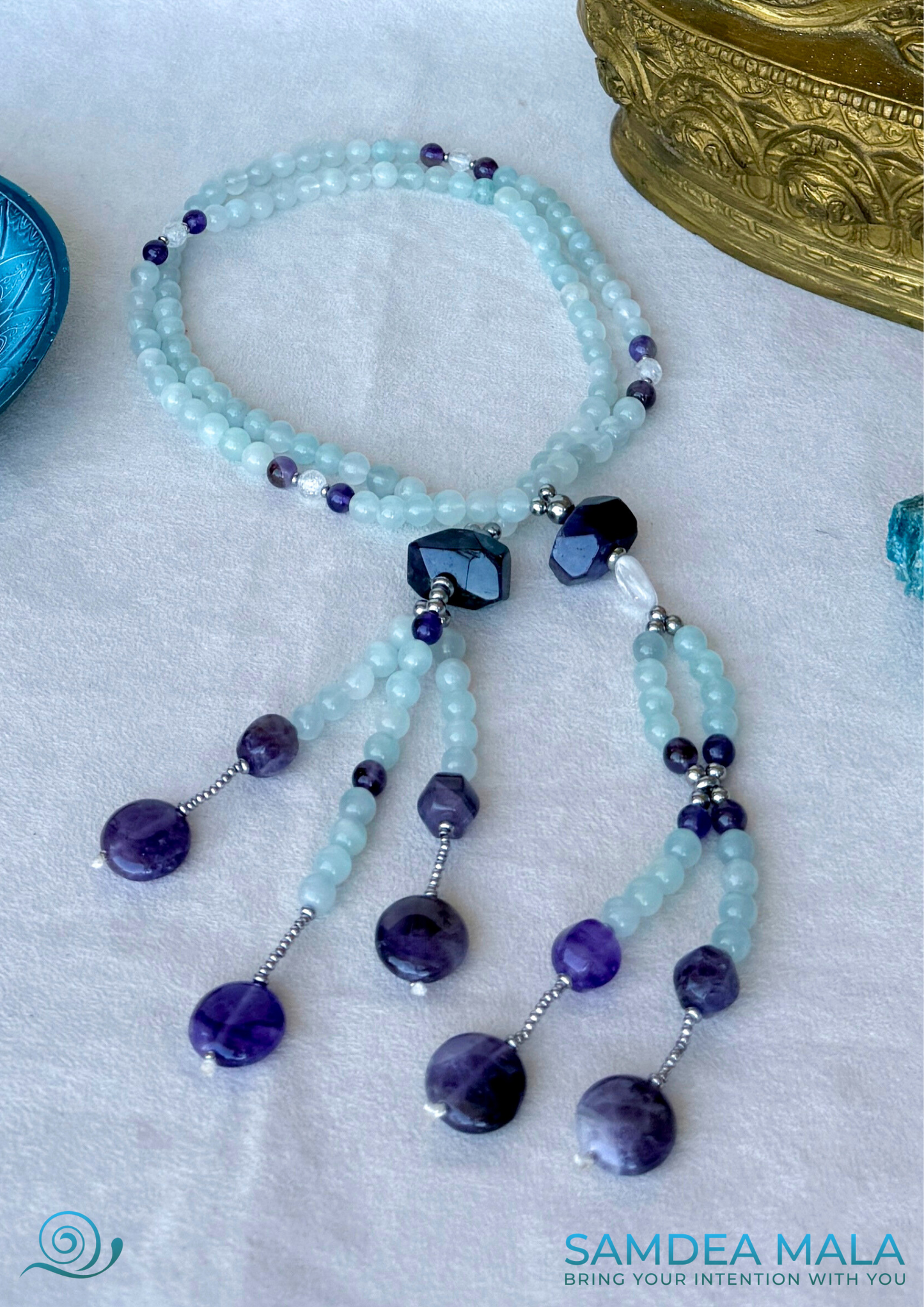 Full view of traditional SGI juzu in natural aquamarine and amethyst beads with clear quartz guru bead at the center. SGI prayer beads