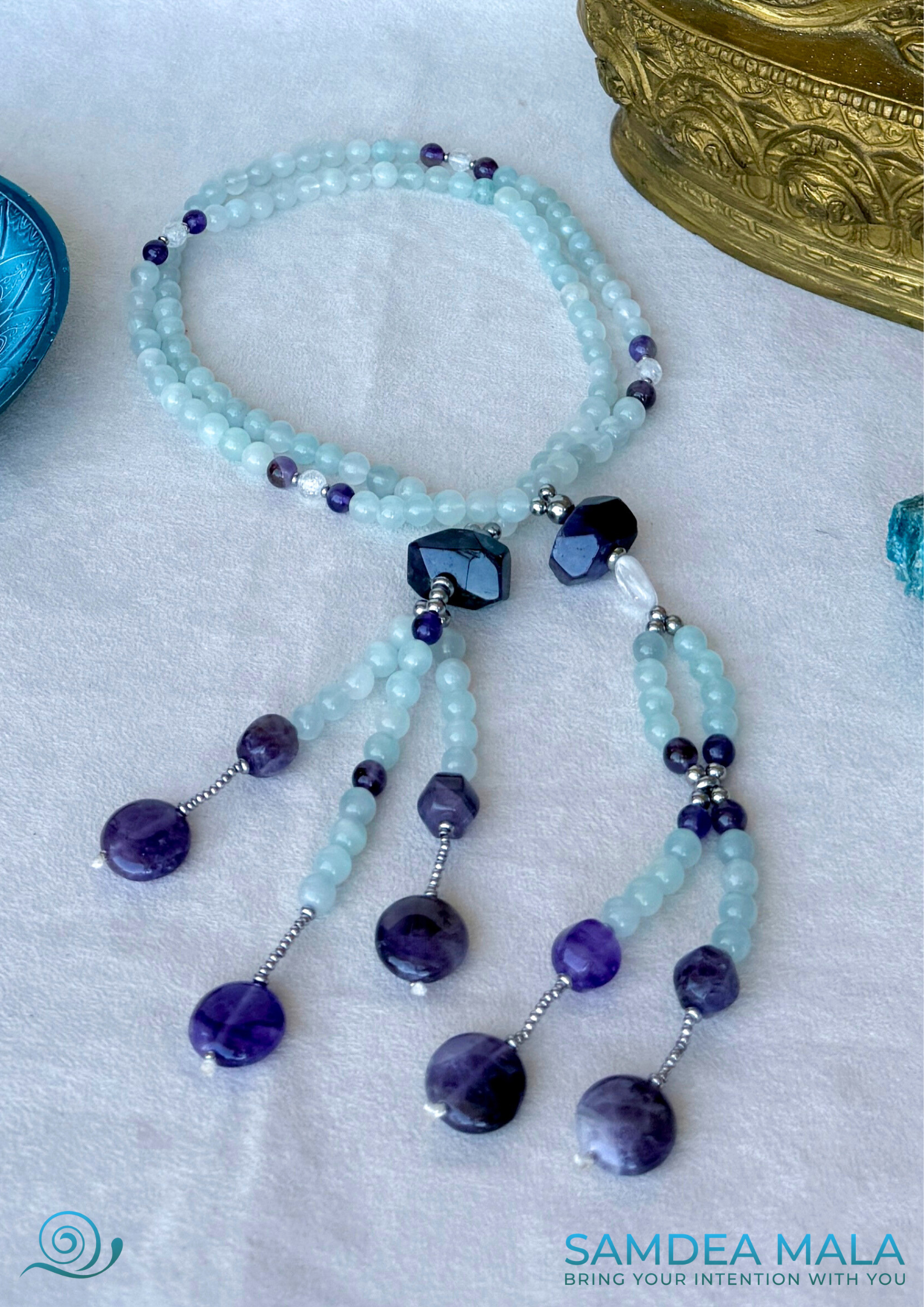 Full view of traditional  SGI juzu in natural aquamarine and amethyst beads with clear quartz guru bead at the center. SGI prayer beads