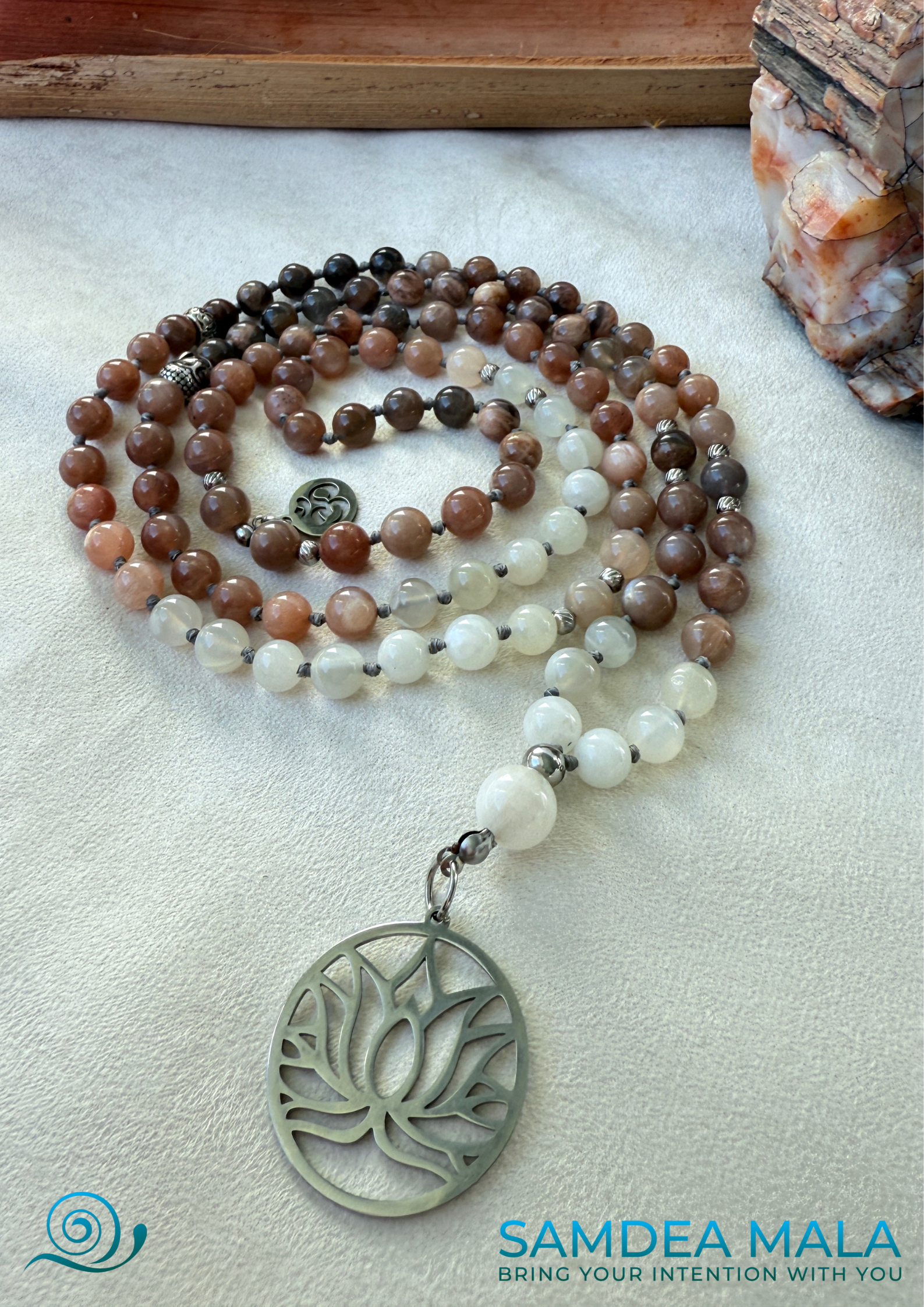 Samdea Mala - Moonstone Mala with Buddha, Lotus and OM – Hand-Knotted Feminine Energy Mala | Intuition Mala with Lotus Pendant | 108 Beads | Self-Connection & Lunar Magic. Hand knotted, handcrafted in US. 108 moonstone beads in soft pink and gray hues, Spiritual jewelry for intuition, lunar energy, and inner self-connection.