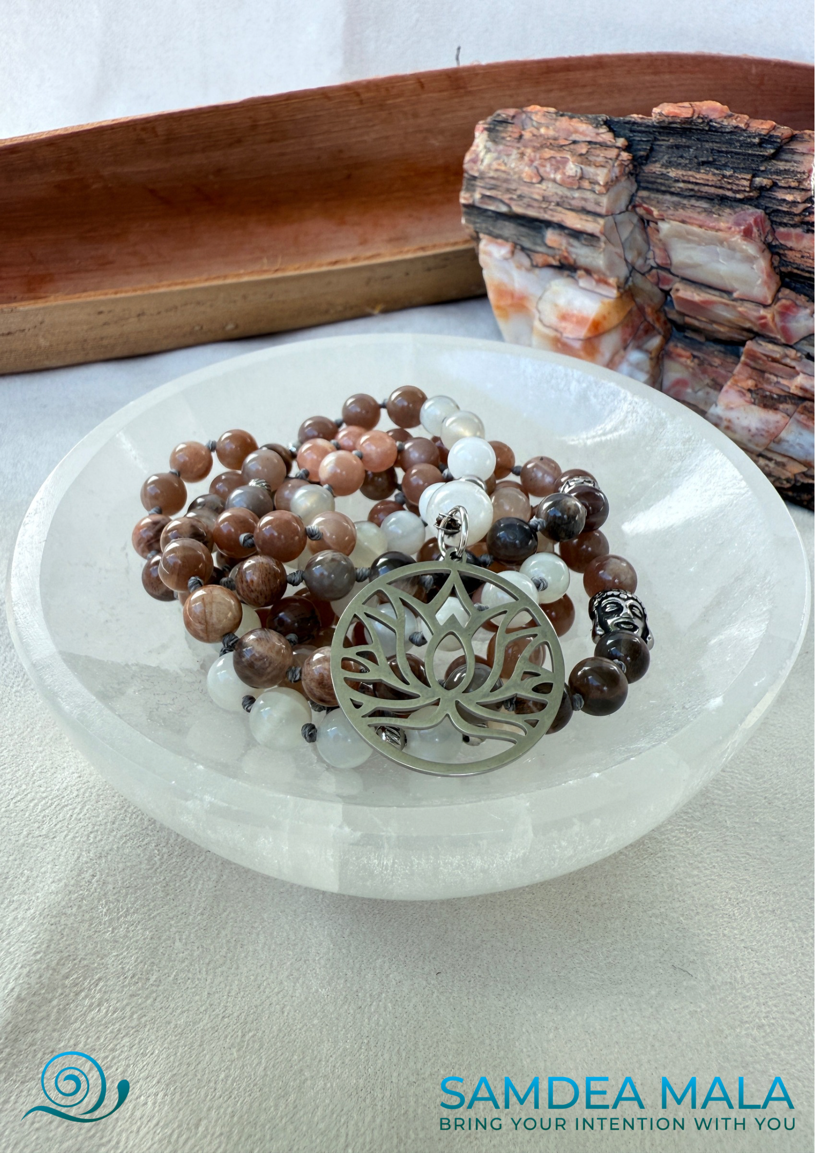 Moonstone Mala on a selenite bowl – Hand-Knotted Feminine Energy Mala | Intuition Mala with Lotus Pendant | 108 Beads | Self-Connection & Lunar Magic. Hand knotted, handcrafted in US. 108 moonstone beads in soft pink and gray hues, Spiritual jewelry for intuition, lunar energy, and inner self-connection. Moonstone mala necklace.