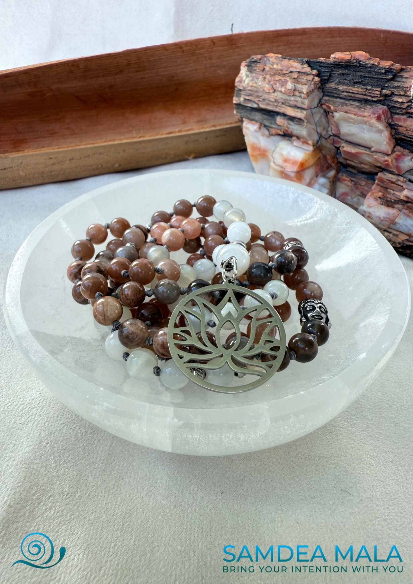 Moonstone Mala on a selenite bowl – Hand-Knotted Feminine Energy Mala | Intuition Mala with Lotus Pendant | 108 Beads | Self-Connection & Lunar Magic. Hand knotted, handcrafted in US. 108 moonstone beads in soft pink and gray hues, Spiritual jewelry for intuition, lunar energy, and inner self-connection. Moonstone mala necklace.