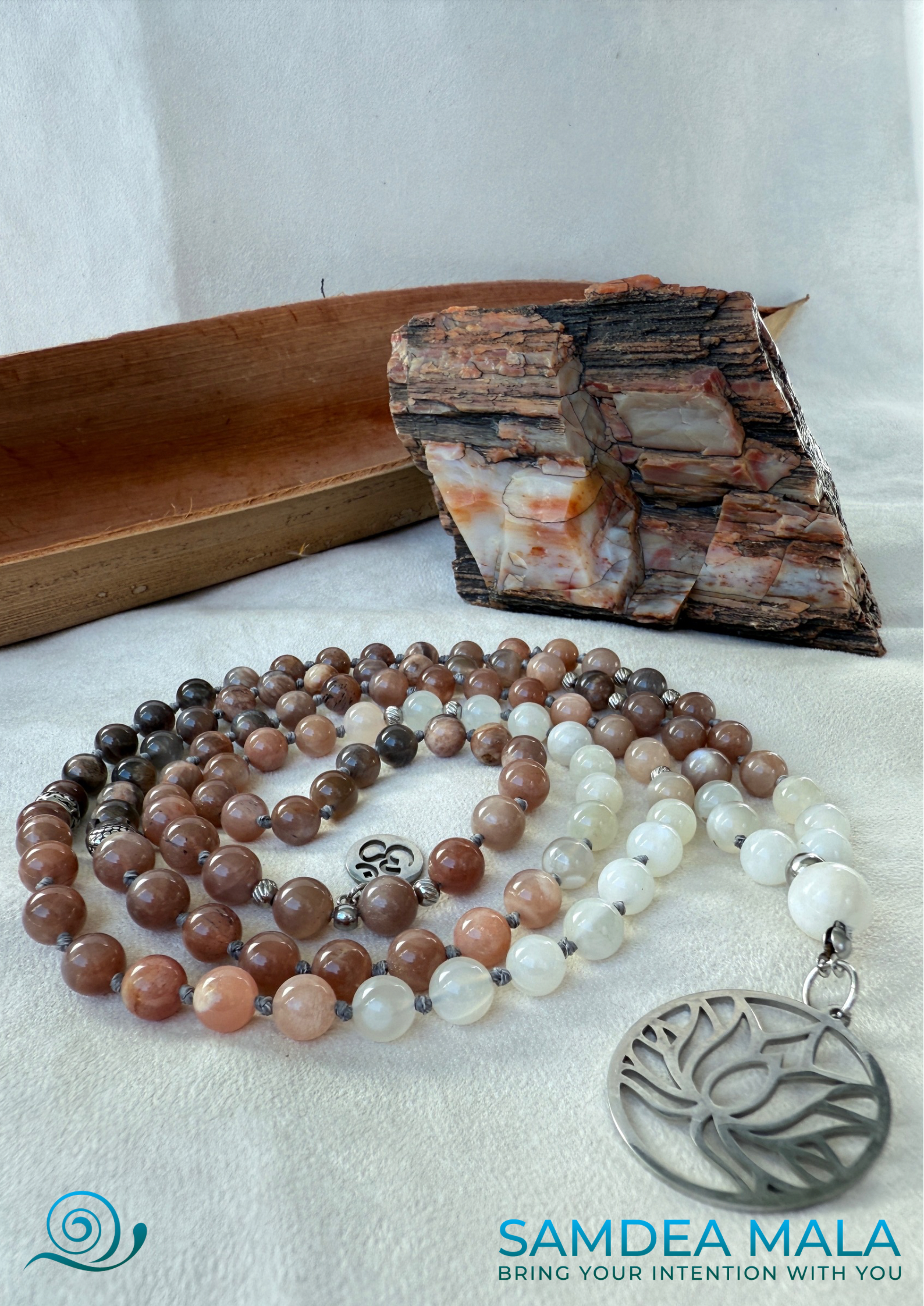 Samdea Mala - Moonstone Mala with Buddha, Lotus and OM - Feminine Energy Mala | Intuition Mala with Lotus Pendant | 108 Beads | Self-Connection & Lunar Magic. Hand knotted, handcrafted in US. 108 moonstone beads in soft pink and gray hues, Spiritual jewelry for intuition, lunar energy, and inner self-connection.