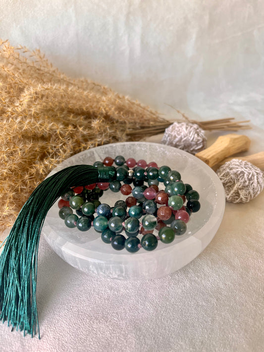 Selenite Smudge Bowl & Crystal Charging holding mala bracelet beads. Natural gemstone mala on selenite bowl for energy cleansing. Samdea Mala