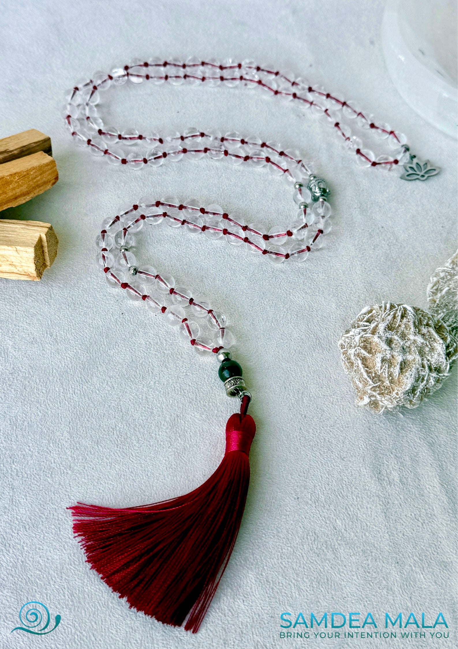 Sphatik Mala Beads with red cord and red atssal and Buddha charm, full view. Samdea Mala in clear quartz mala beads for meditation and mantra recitation On mani Pamde Hum. Mala for meditation with 108 prayer beads, Spiritual gift.