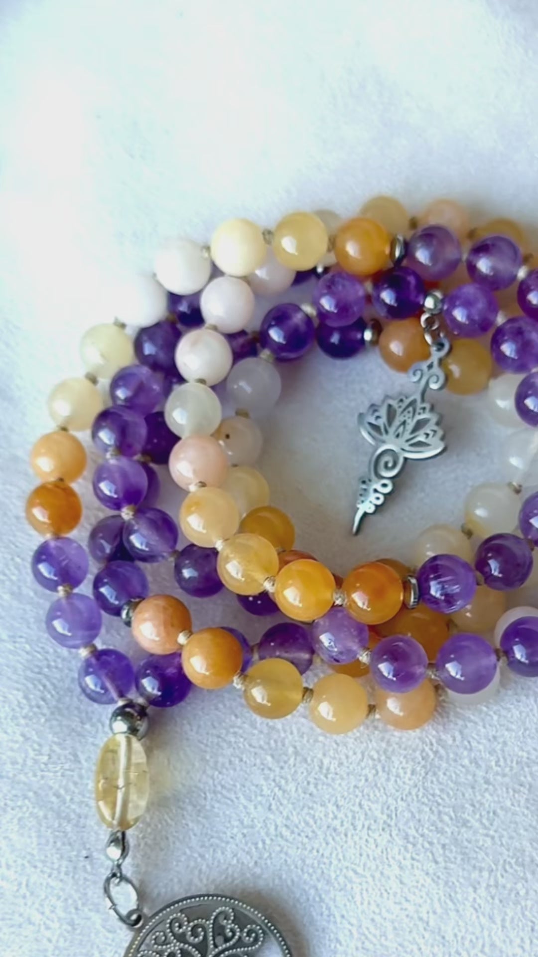 Video: mala beads moving in hand—amethyst shimmer, golden jade warmth, citrine meru sparkle