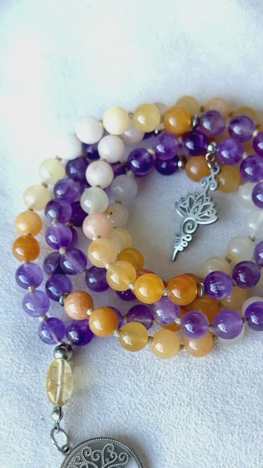 Video: mala beads moving in hand—amethyst shimmer, golden jade warmth, citrine meru sparkle