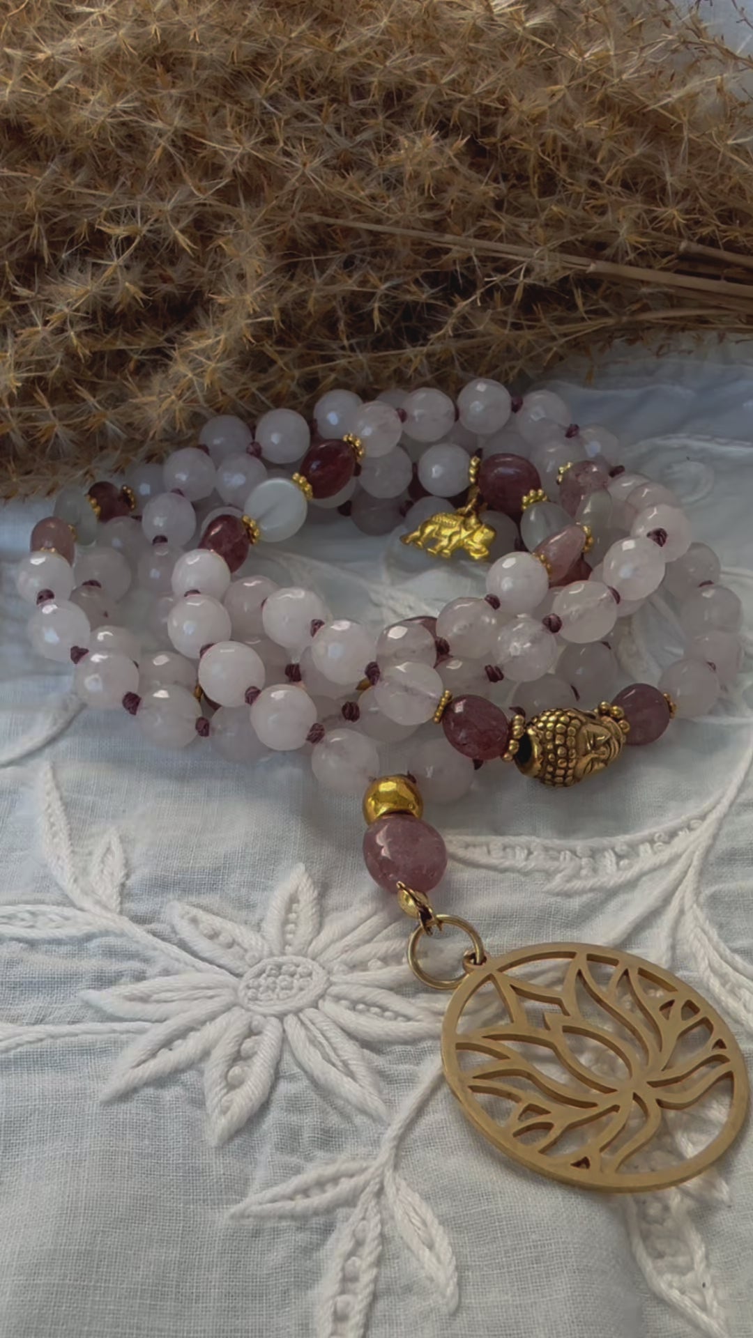 Video preview of Rose Quartz & Strawberry Quartz Mala – Emotional Healing and Self-Love | Lotus Flower Pendant | 108 Beads Meditation Necklace close-up of lotus pendant and Buddha charm