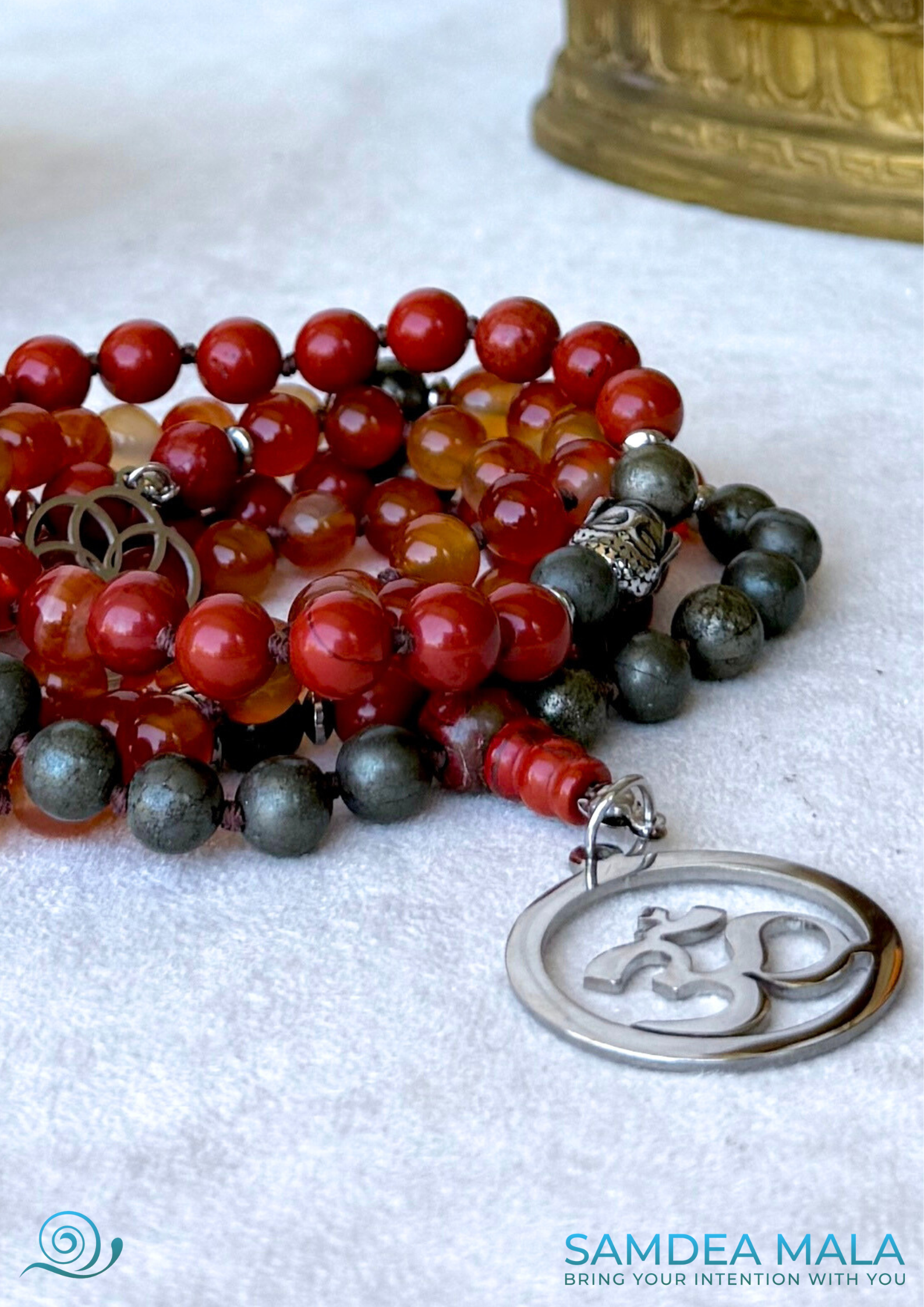 Close up of Grounding Mala Necklace – Red Jasper, Carnelian, Pyrite | 108 Beads for Courage, Vitality & Inner Strength | Root Chakra Mala - zodiac sign Aries, detail of OM pendant