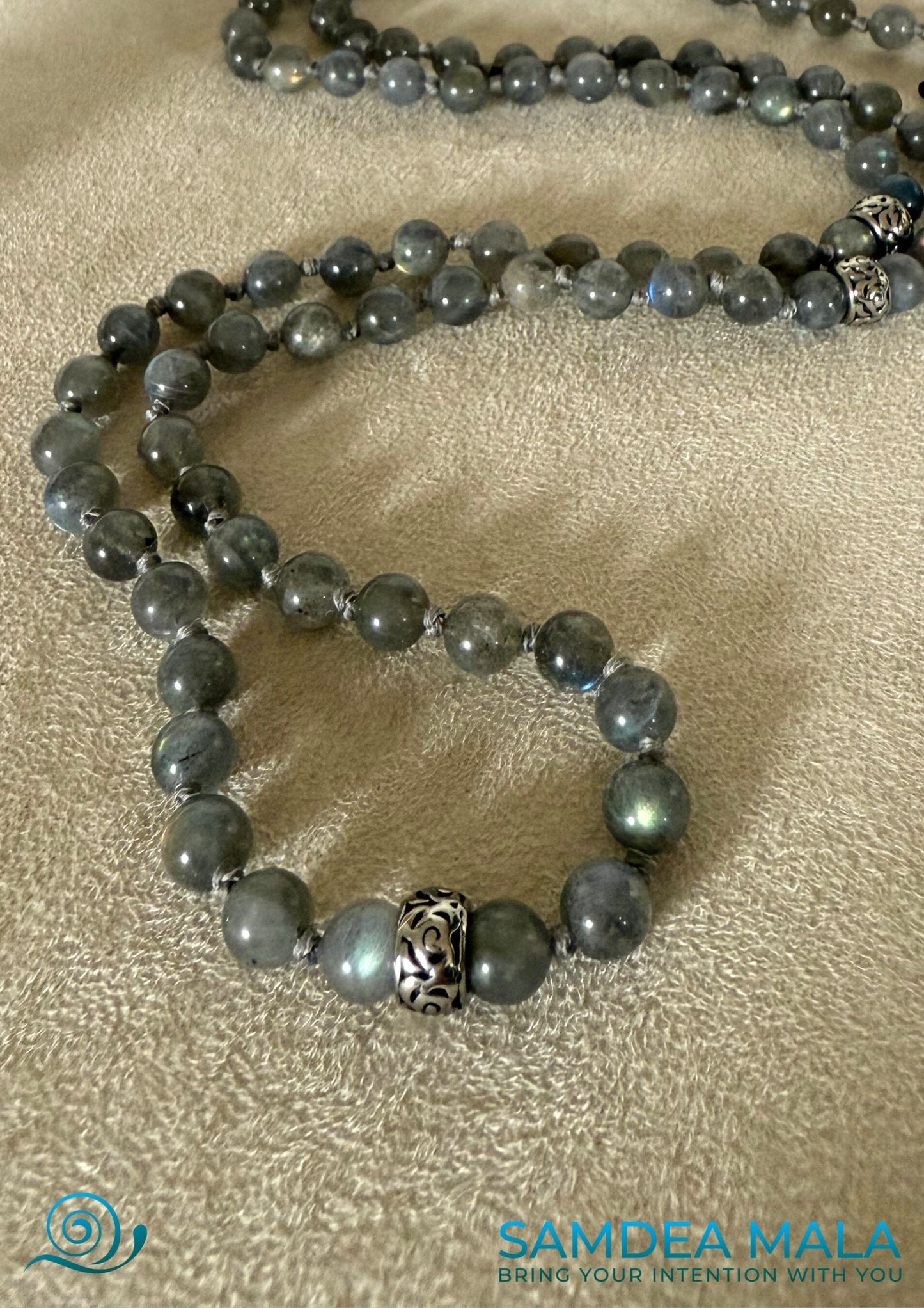 Close-up Samdea Mala bracelet in labradorite – handmade spiritual jewelry with grey-blue natural stones and a steel Buddha head charm. A meditation bracelet for intuition and inner vision.