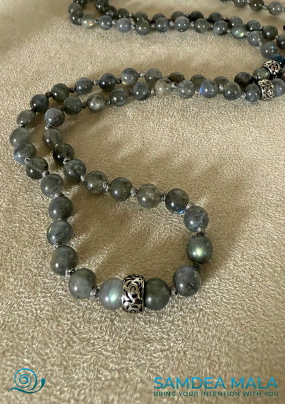 Close-up Samdea Mala bracelet in labradorite – handmade spiritual jewelry with grey-blue natural stones and a steel Buddha head charm. A meditation bracelet for intuition and inner vision.