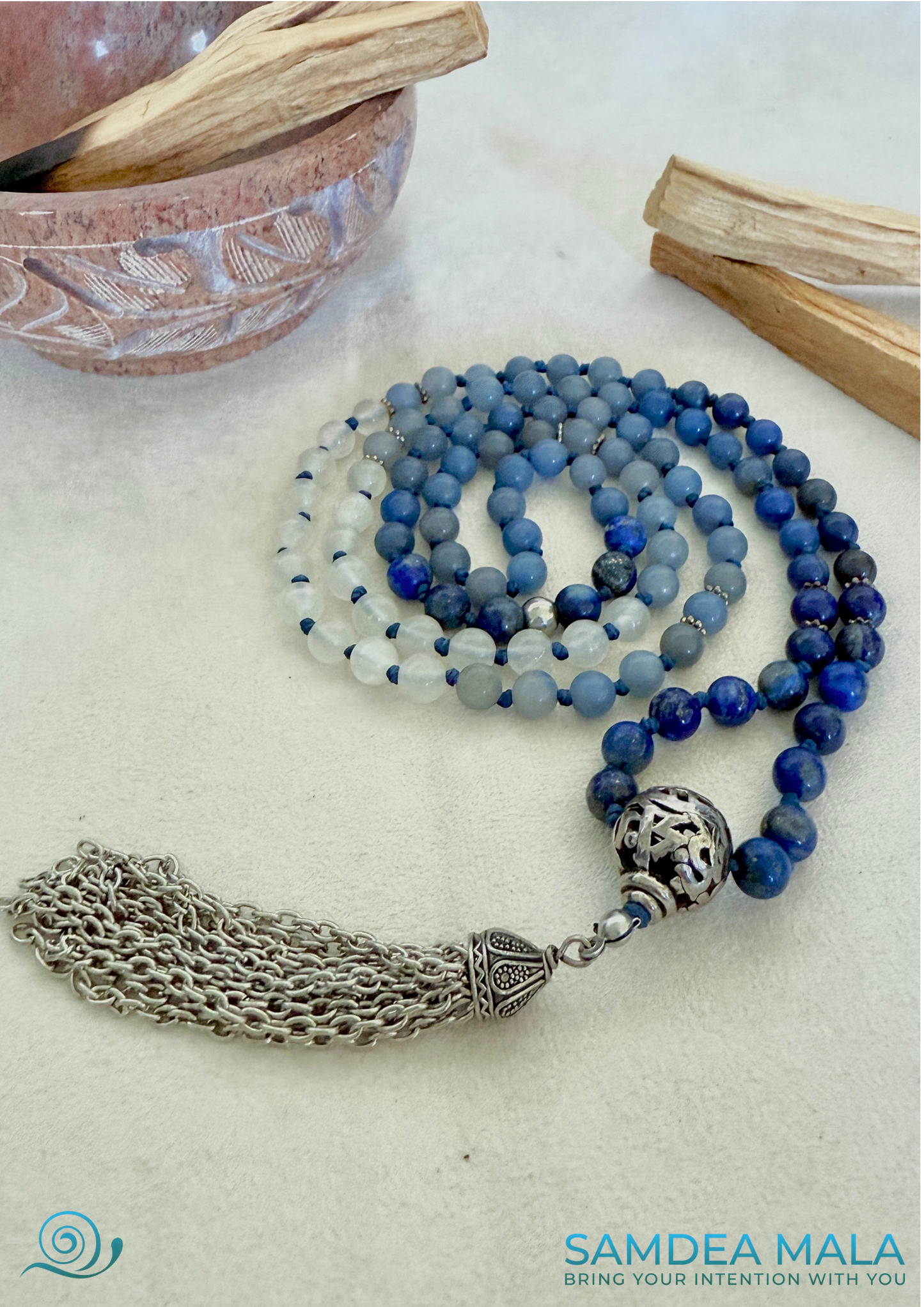 Close-up of lapis lazuli beads with gold flecks on a blue aventurine and white jade meditation mala