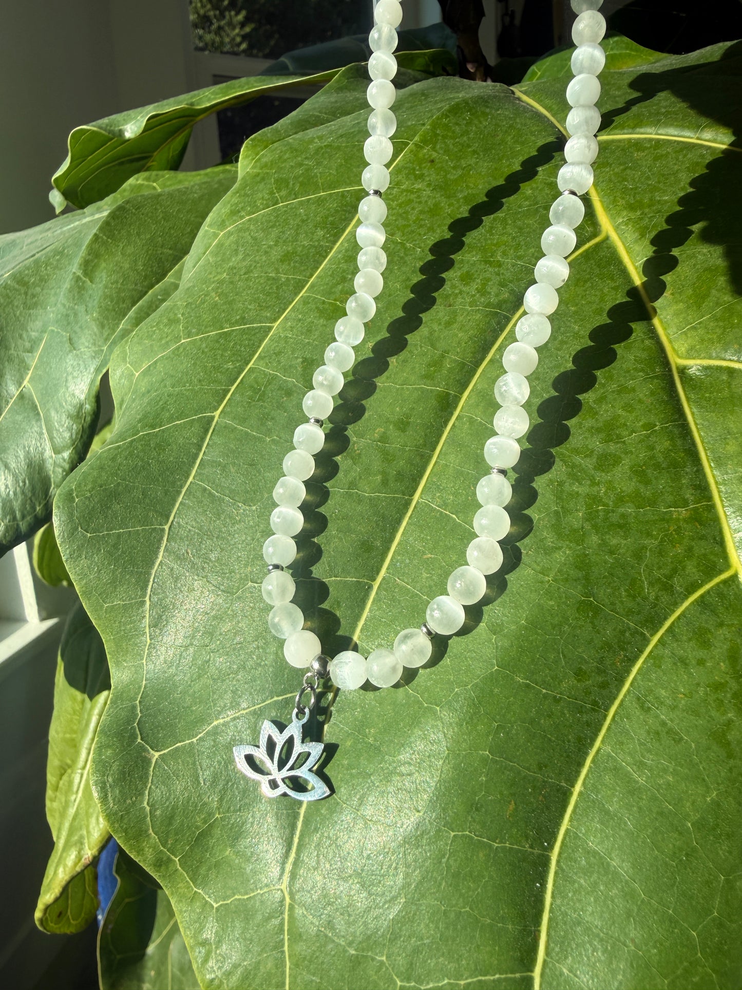 Close-up of selenite and lotus choker necklace, a special gift for purity and higher connection. Small lotus charm stainless steel.