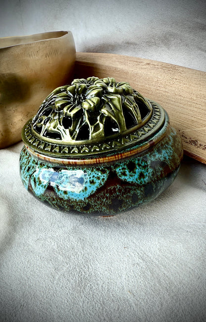Deep blue ceramic container with brass lid placed on a wooden surface as a mindful home sanctuary detail.