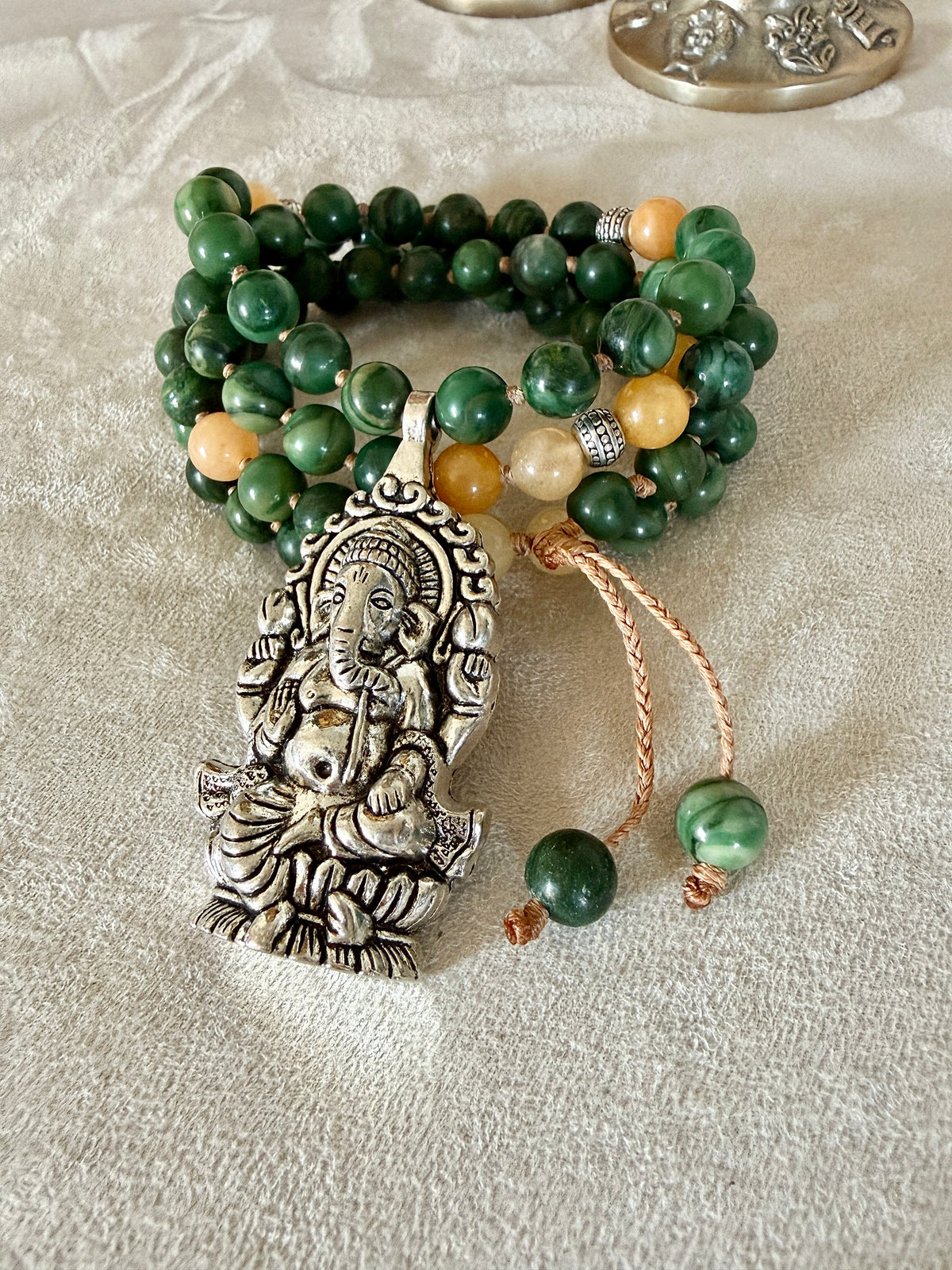 Detail of Ganesh pendant for abundance on a short green and yellow mala for every day meditation