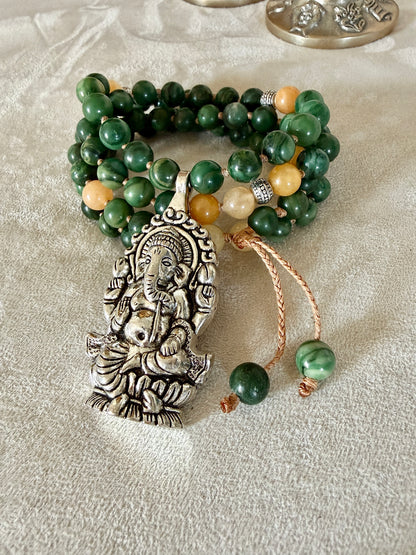 Detail of Ganesh pendant for abundance on a short green and yellow mala for every day meditation