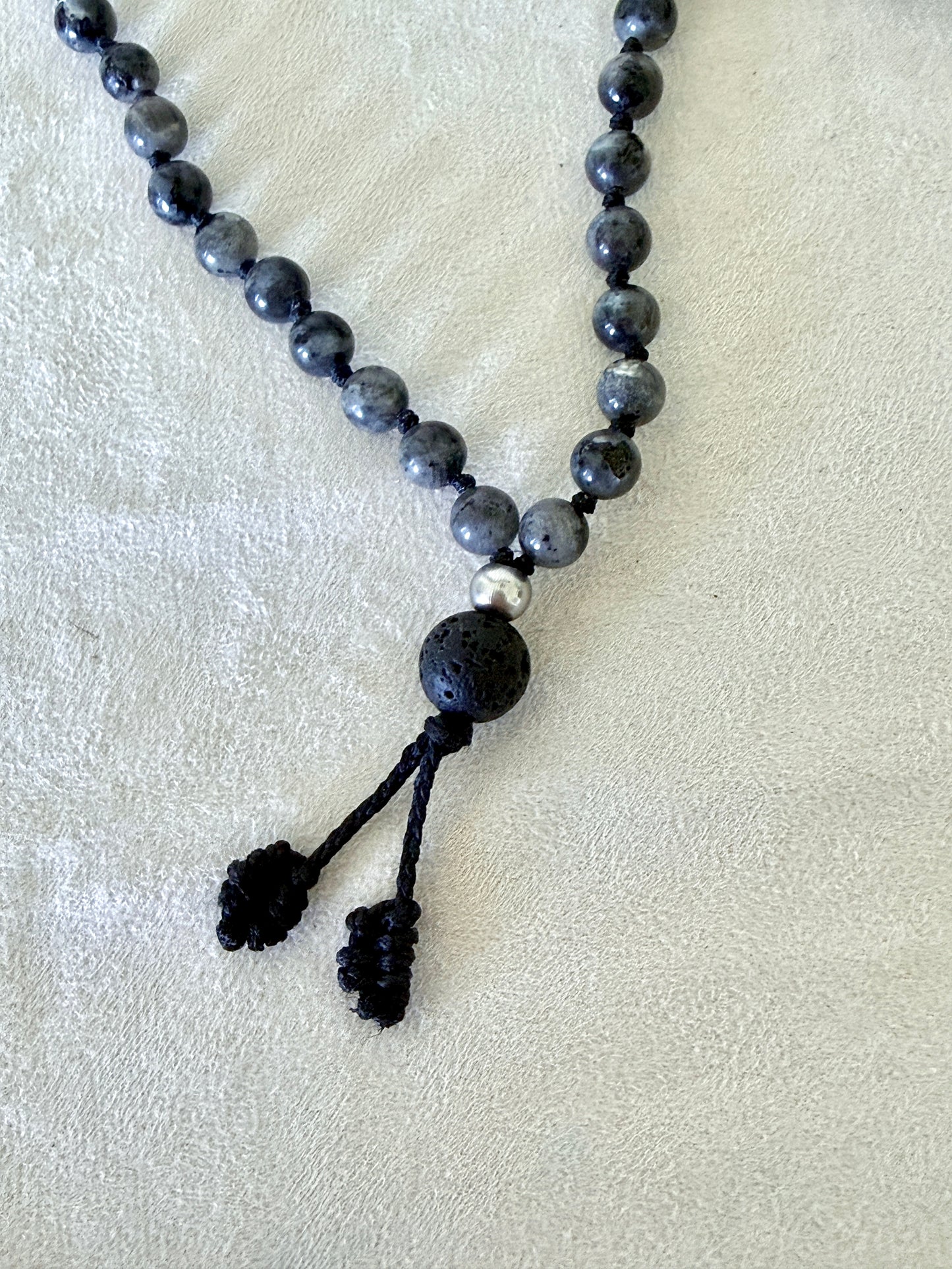 Mala for man. Detail of Grey larvikite mala necklace with 6 mm beads, lava stone meru, stainless steel Buddha charm and grounding spiritual jewelry. Natural gemstone mala for meditation.
