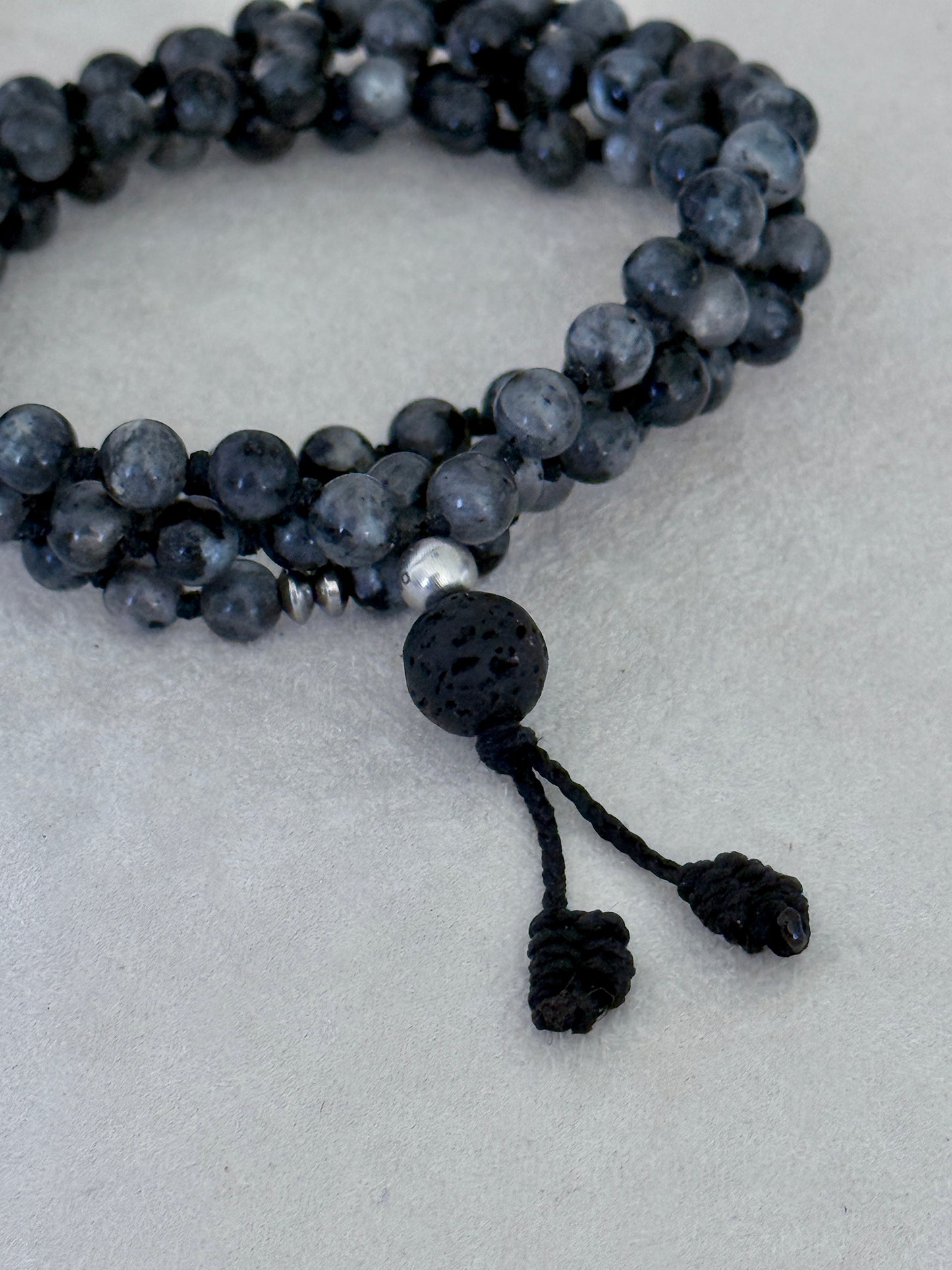 Mala for man. Detail of Natural grey larvikite mala necklace with 6 mm beads, lava stone meru, stainless steel Buddha charm and grounding spiritual jewelry by Samdea Mala