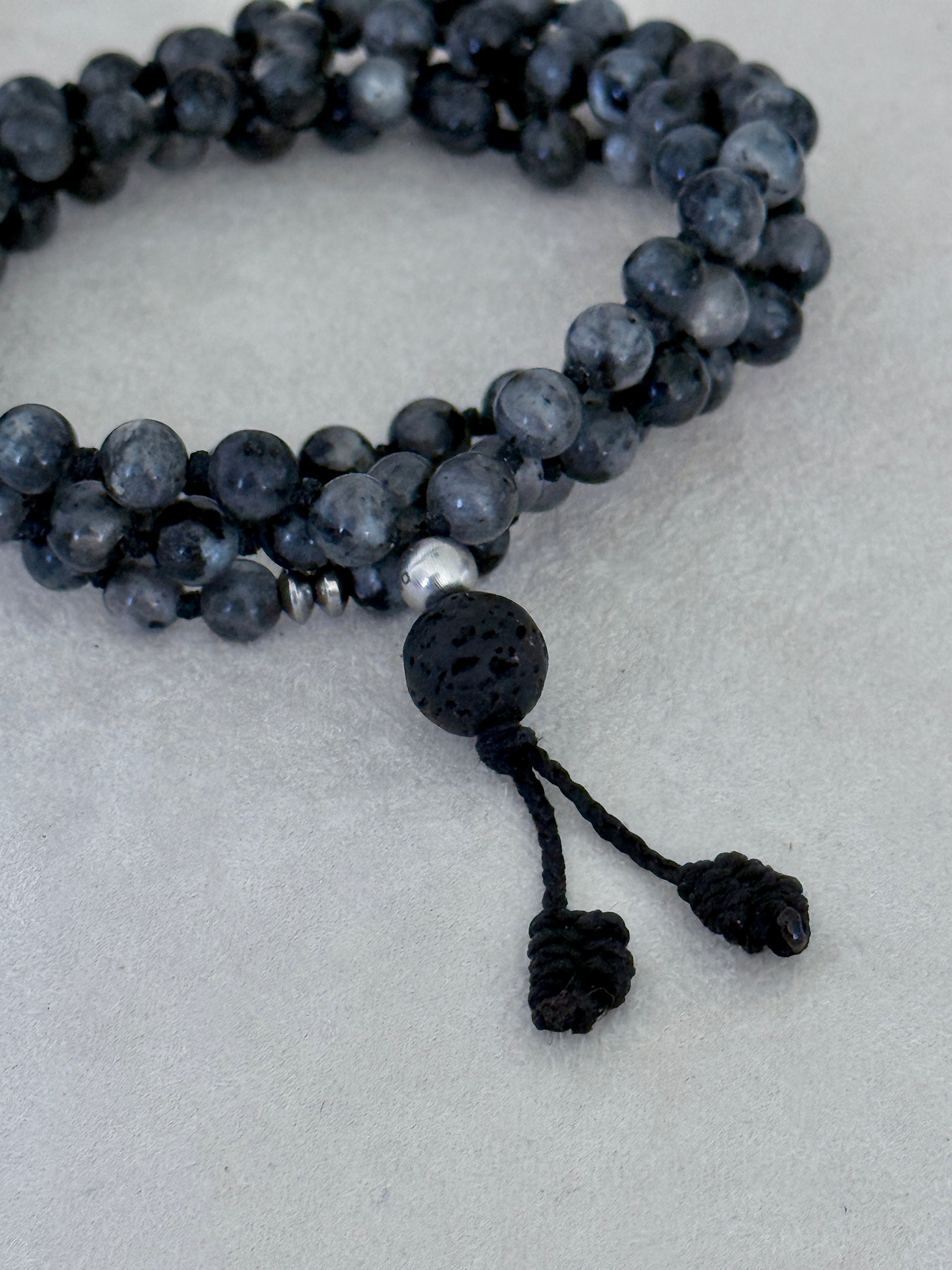 Mala for man. Detail of Natural grey larvikite mala necklace with 6 mm beads, lava stone meru, stainless steel Buddha charm and grounding spiritual jewelry by Samdea Mala