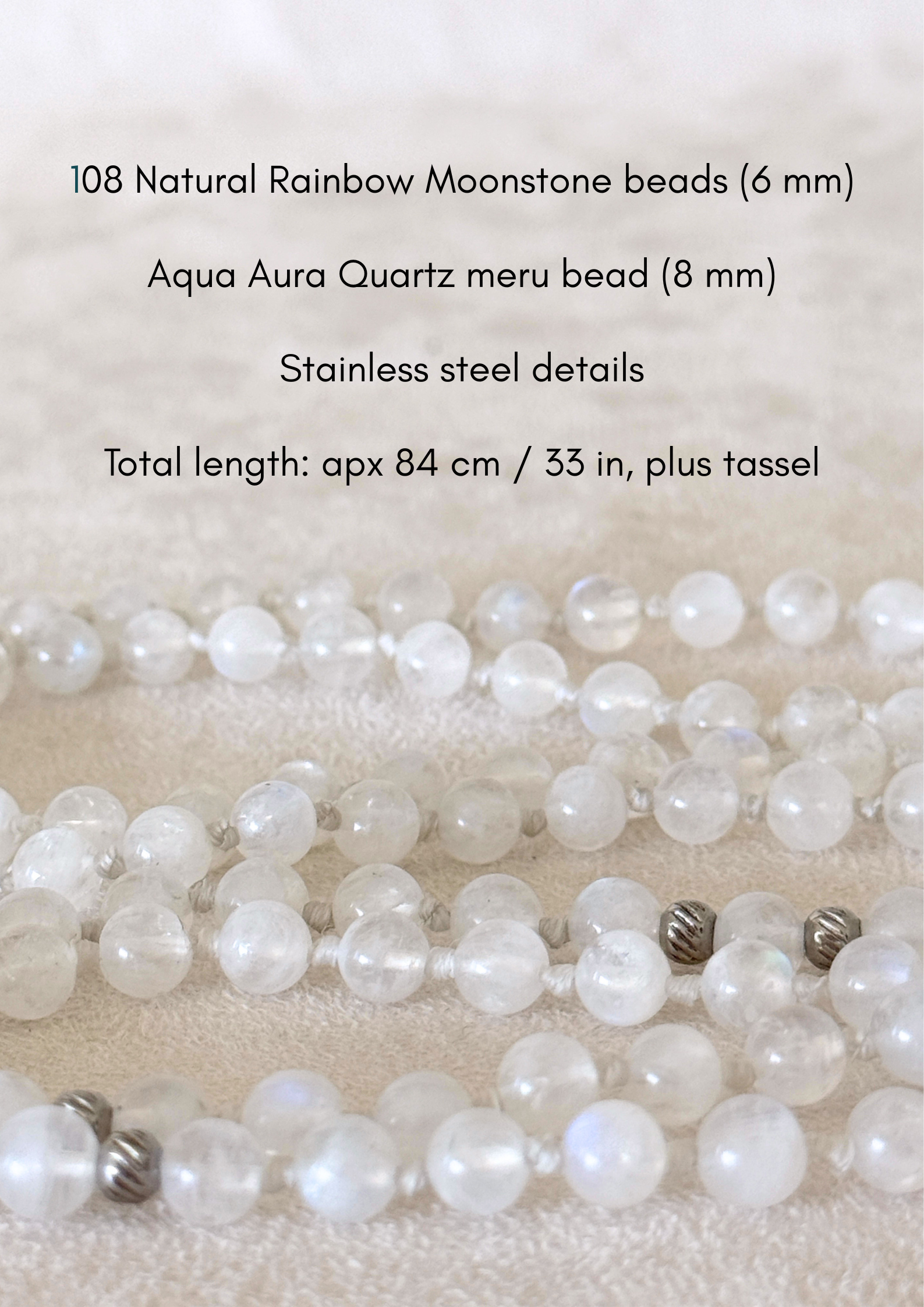 Detail of a  Handmade Rainbow Moonstone mala for meditation with 108 prayer beads, 6 mm natural gemstone beads, Aqua Aura Quartz meru, stainless steel details, small lotus charm, and tassel, created for meditation, breathwork, mantra repetition, mindfulness, and intentional practice. Samdea Mala
