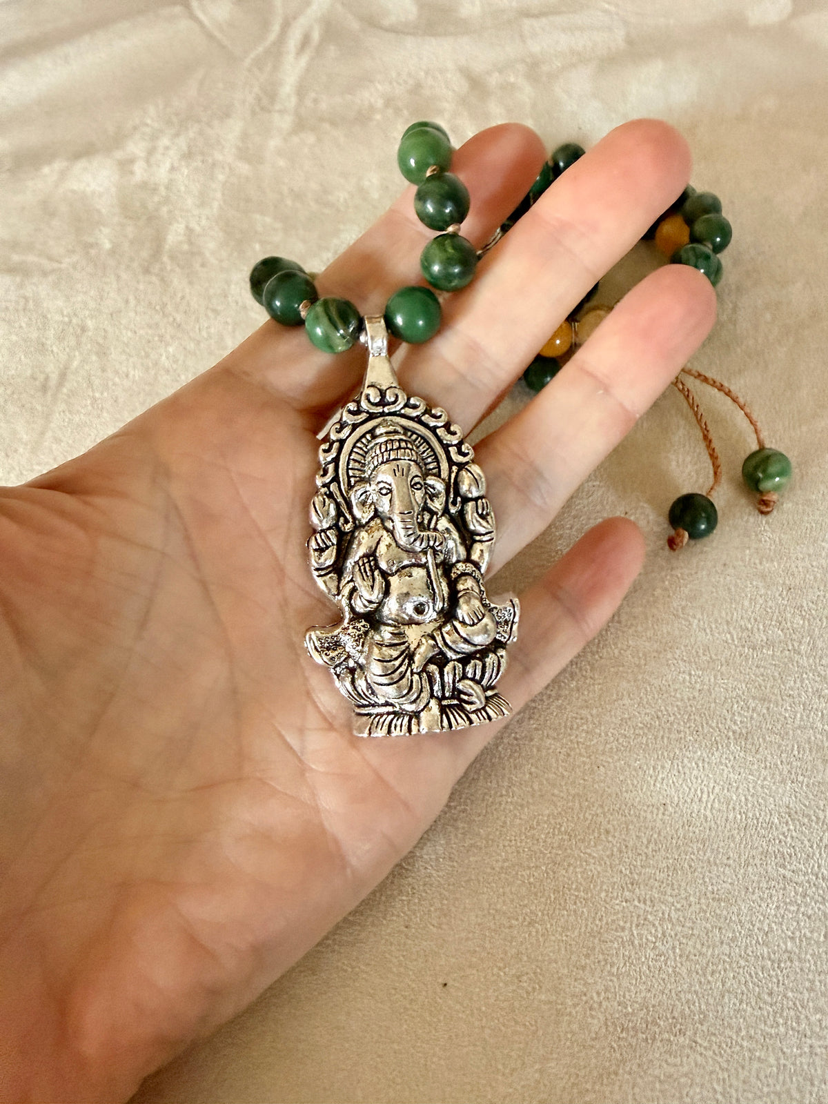 Detail of antique-style Ganesha pendant symbolizing removal of obstacles on a hand