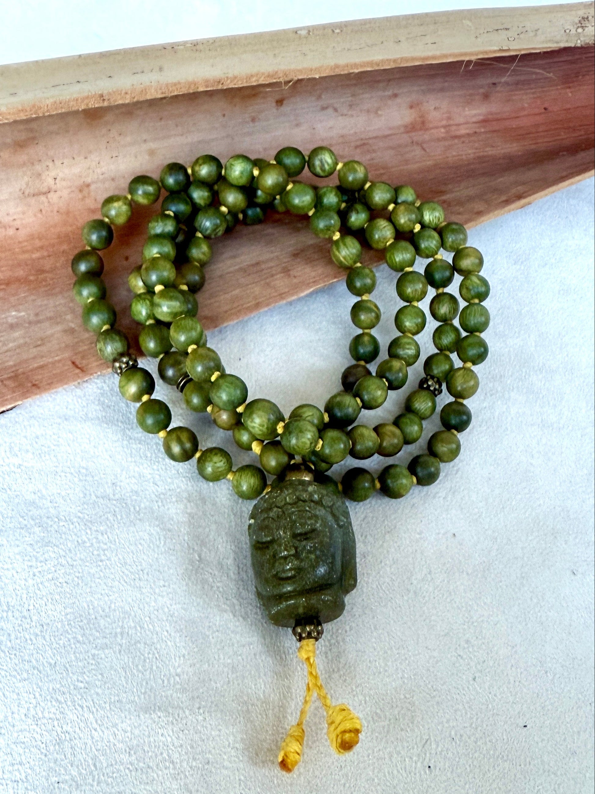 Hand-knotted sandalwood mala with carved jade Buddha pendant for meditation and mindfulness by samdea mala