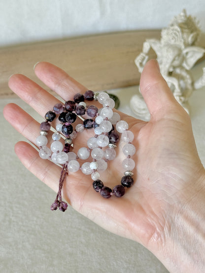Pause Breathing half mala bracelet resting in an open palm, handmade with garnet and rose quartz
