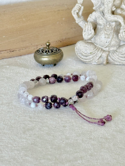 Pause Breathing half mala bracelet laid flat with a Ganesha statue, garnet and rose quartz beads for mindful breathing