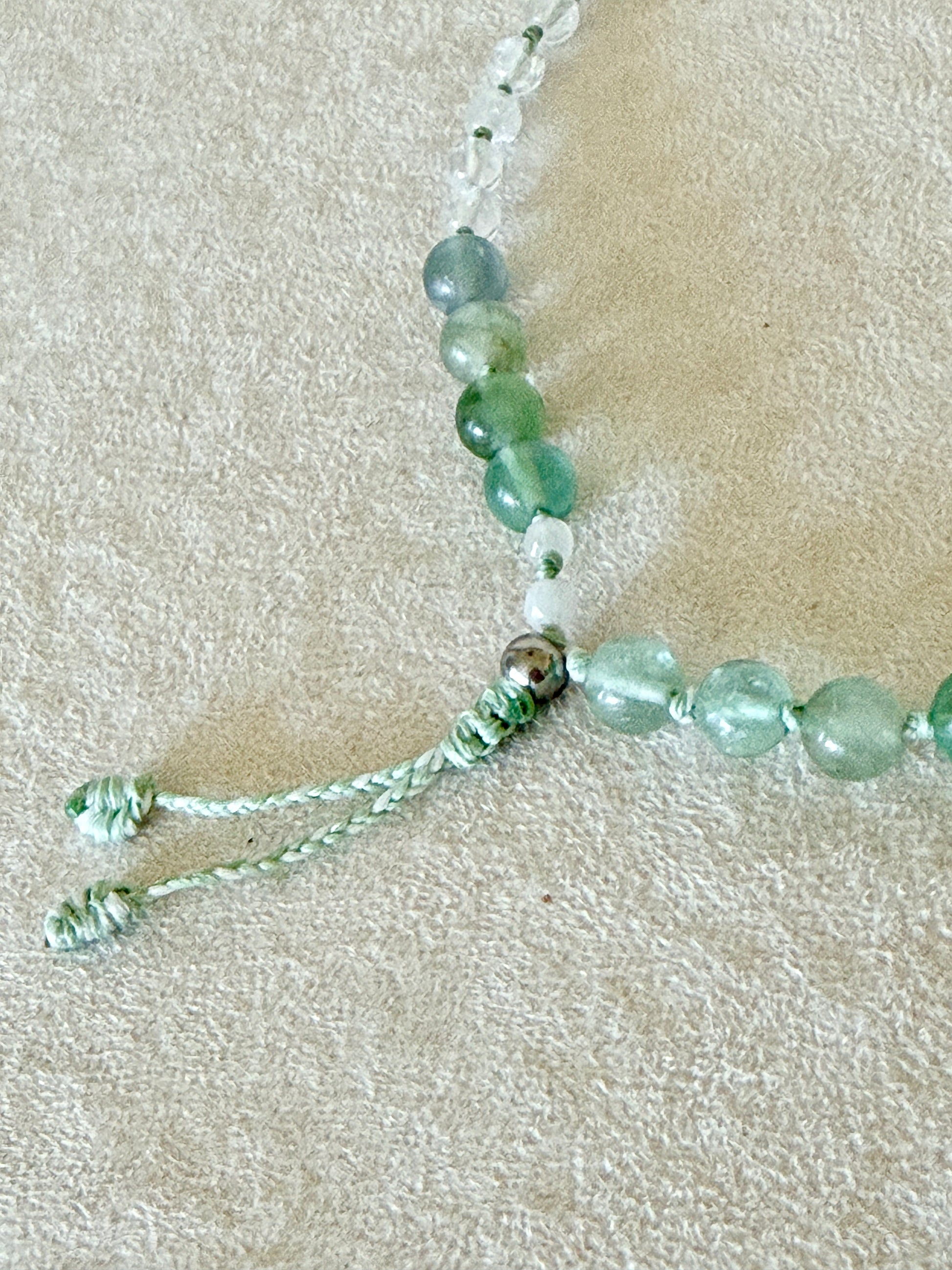 Dettaglio della chiusura regolabile in macramè del bracciale mezzo mala Pause Breathing, con grani di fluorite e quarzo ialino