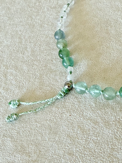 Dettaglio della chiusura regolabile in macramè del bracciale mezzo mala Pause Breathing, con grani di fluorite e quarzo ialino