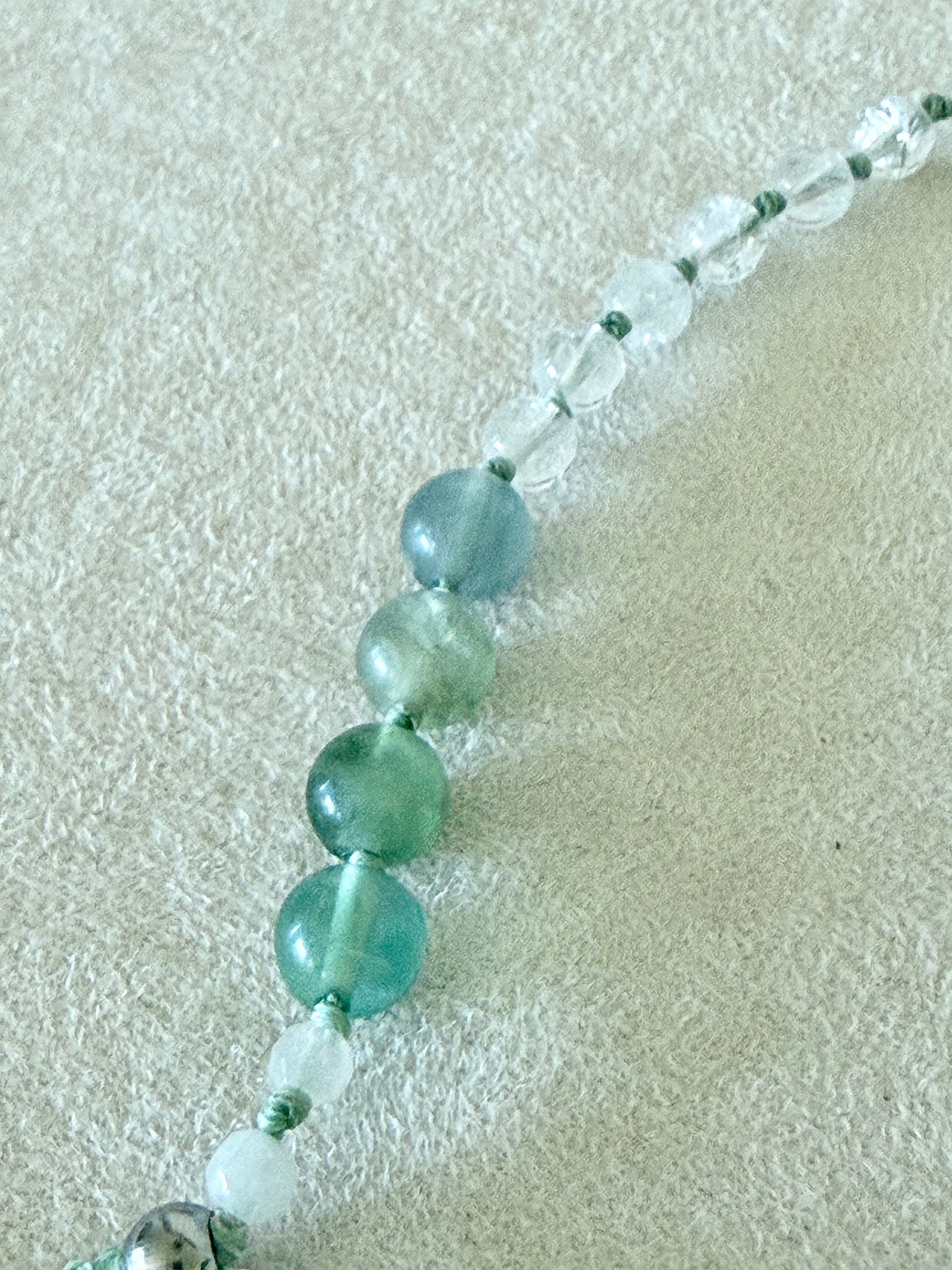 Dettaglio dei grani di fluorite, giada bianca birmana e quarzo ialino del bracciale mezzo mala Pause Breathing