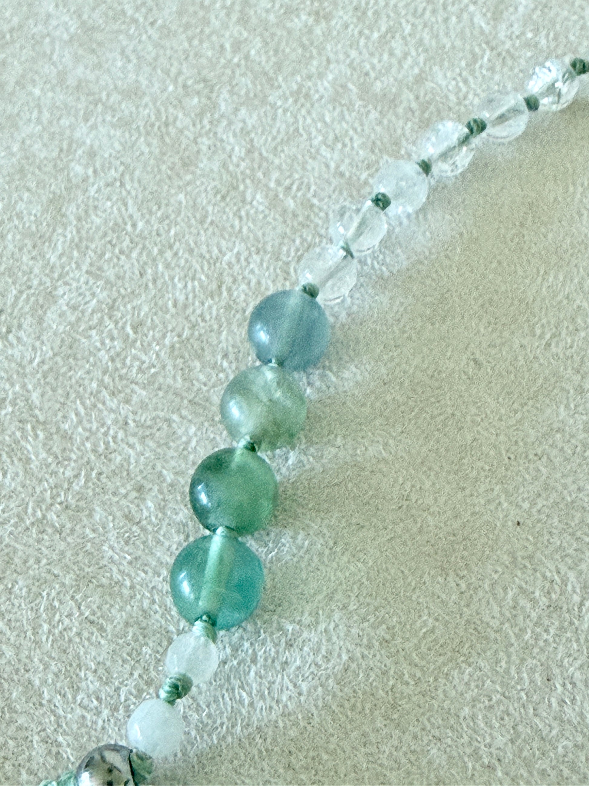 Dettaglio dei grani di fluorite, giada bianca birmana e quarzo ialino del bracciale mezzo mala Pause Breathing
