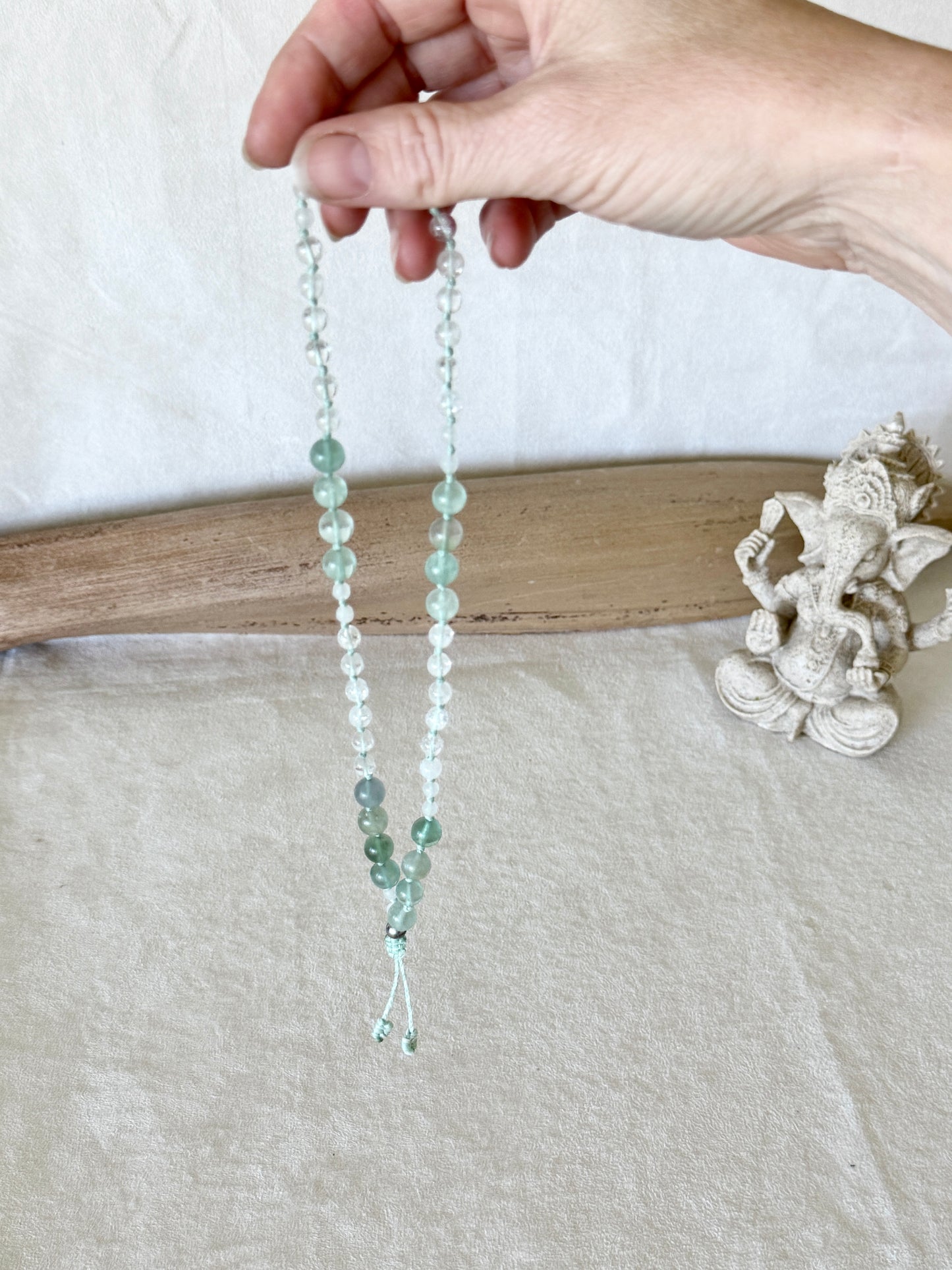 Pause Breathing Mala sollevato per mostrare l'intera fila di grani in fluorite, giada bianca e quarzo ialino