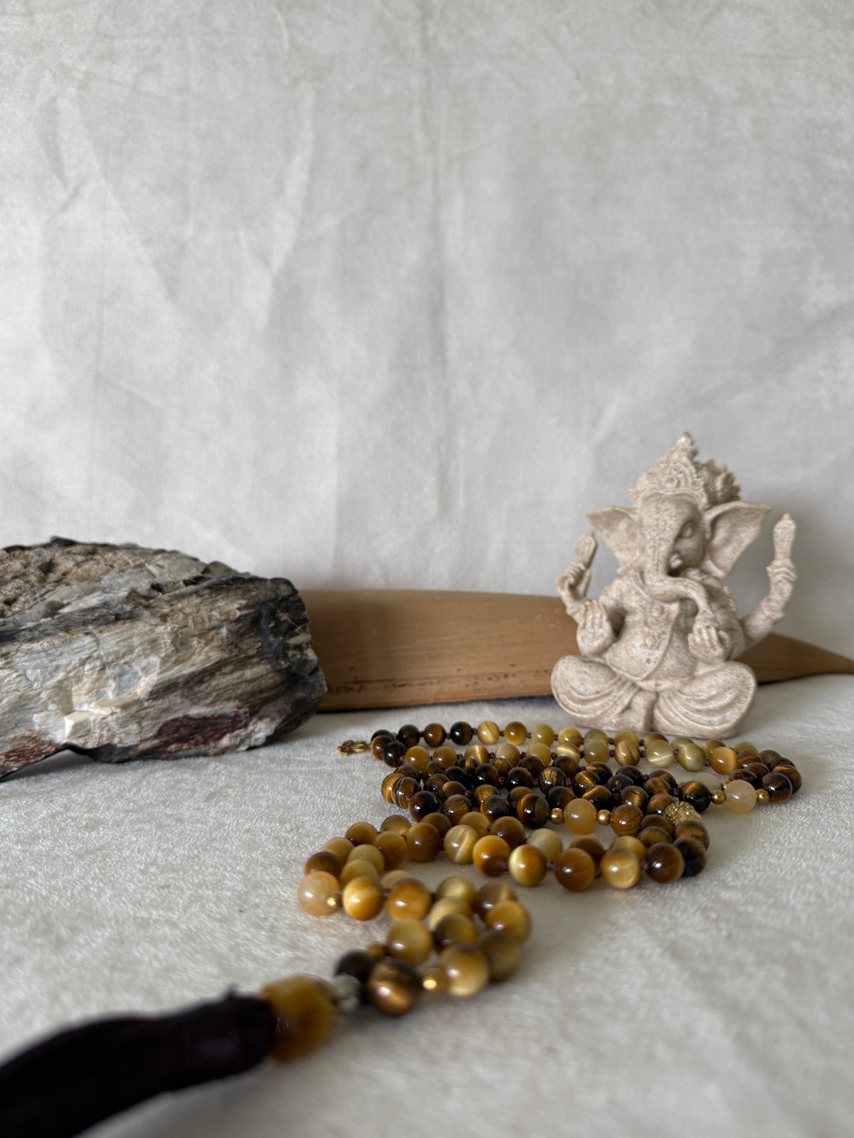 Handmade 108-bead mala necklace with tiger's eye and yellow jade, featuring a Lotus and Buddha charm pendant, designed for grounding, clarity, and centering.