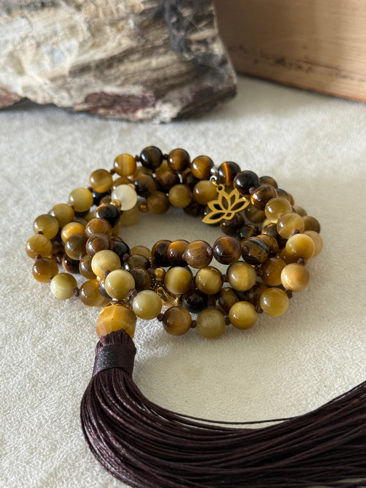 Handmade 108-bead mala necklace with tiger's eye and yellow jade, featuring a Lotus and Buddha charm pendant, designed for grounding, clarity, and centering.