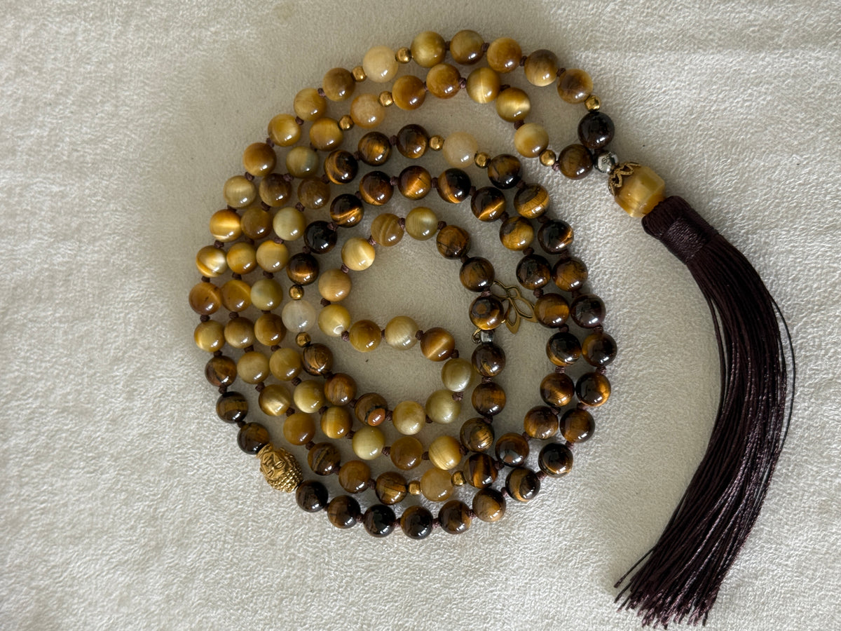 Handmade 108-bead mala necklace with tiger's eye and yellow jade, featuring a Lotus and Buddha charm pendant, designed for grounding, clarity, and centering.
