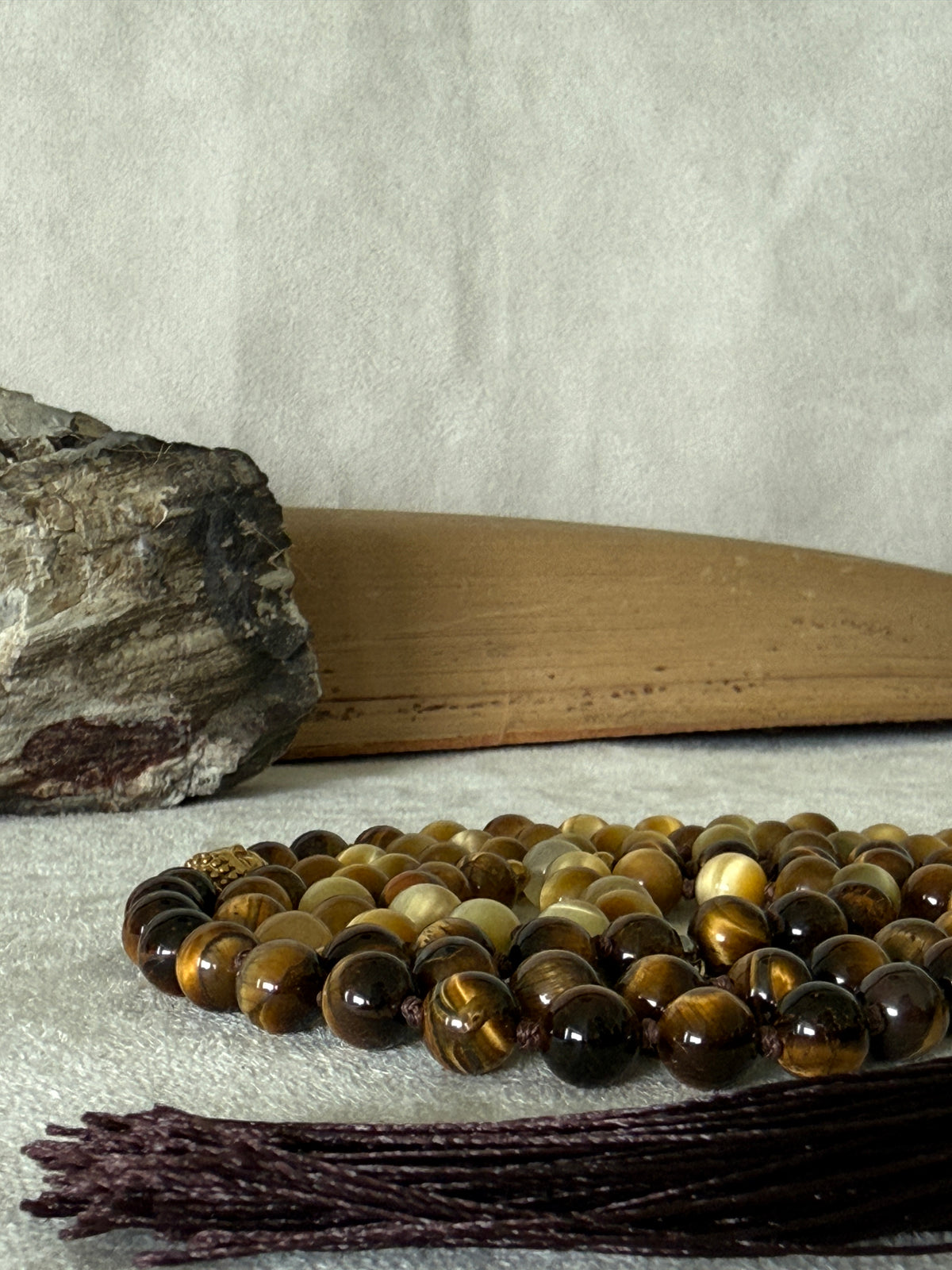 Handmade 108-bead mala necklace with tiger's eye and yellow jade, featuring a Lotus and Buddha charm pendant, designed for grounding, clarity, and centering.