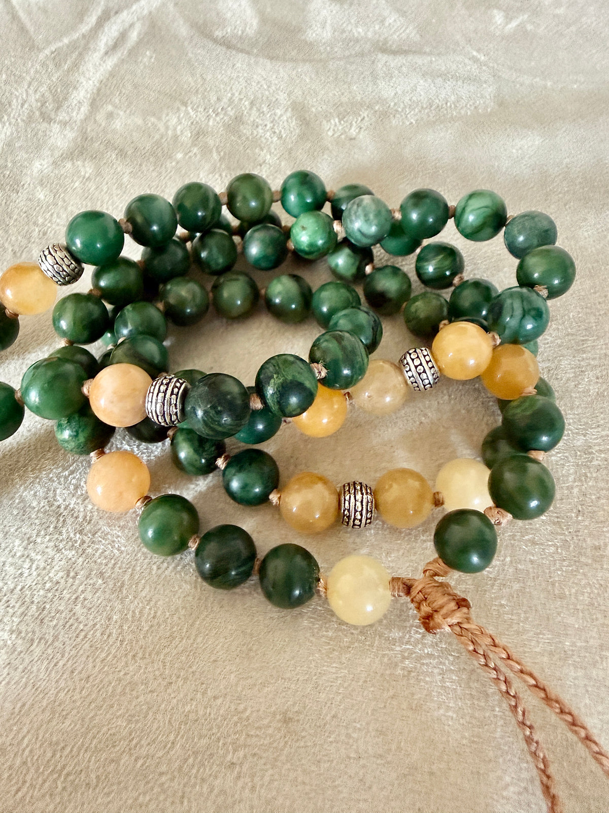 Close-up of green jade beads showing natural marbling on hand-knotted cord