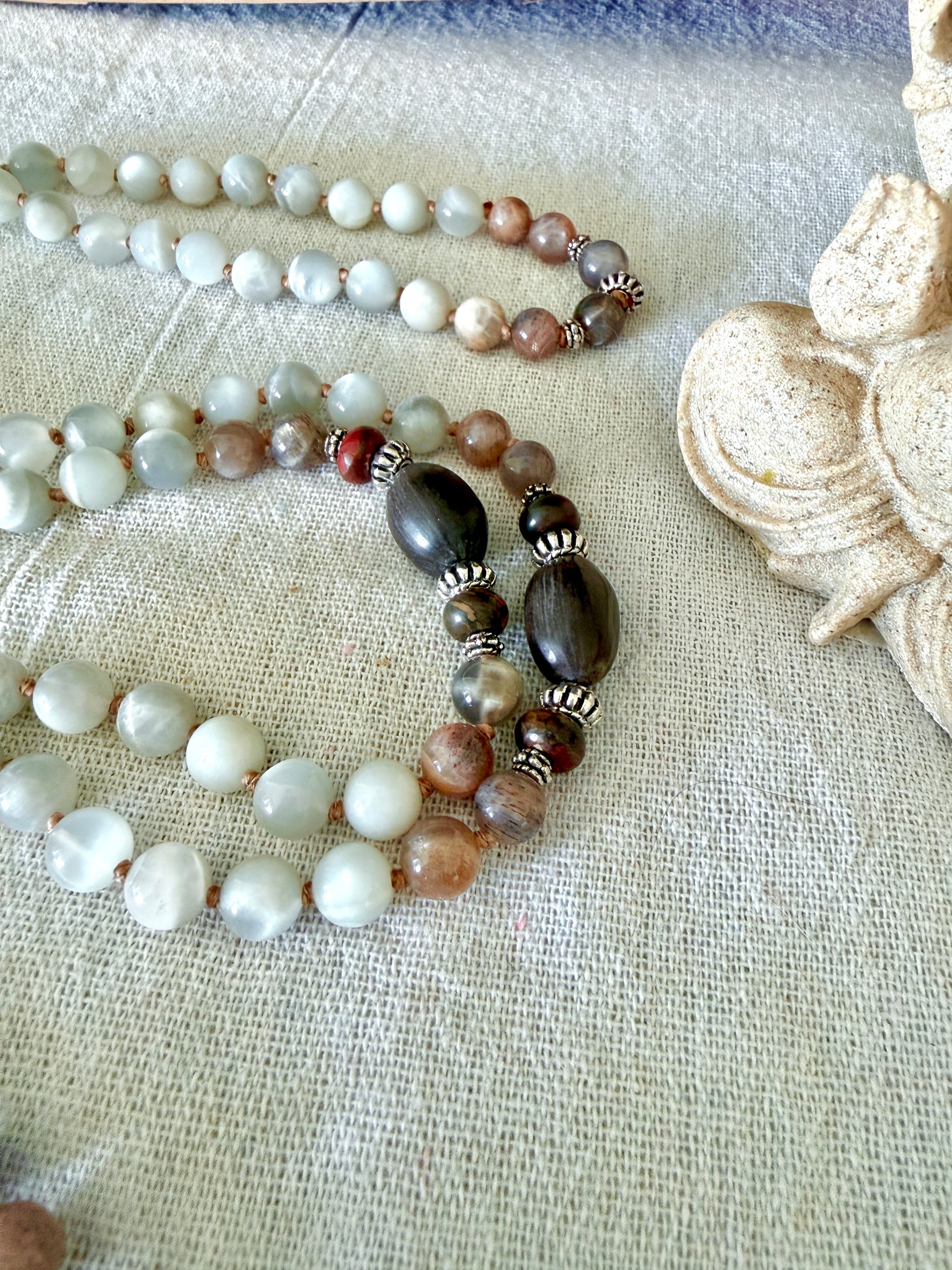 Close-up of Lotus seeds on a  mala necklace with natural gray moonstone from Sri Lanka and black moonstone for meditation